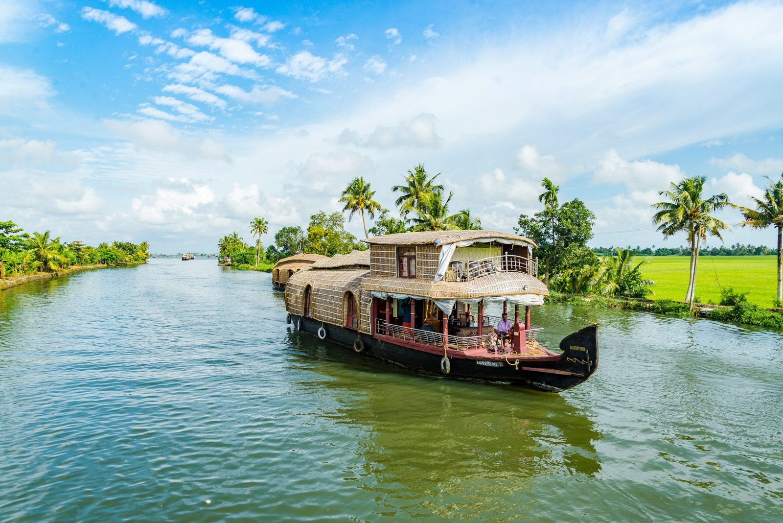 Houseboats resting on the peaceful Alappuzha backwaters in Kerala, reflecting the slow and restorative mood of a retreat in India.
