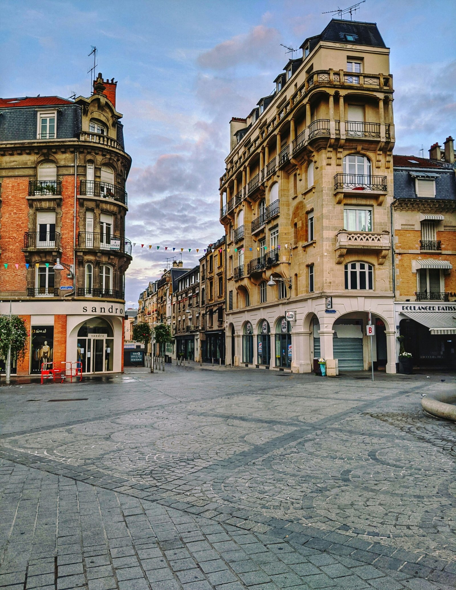 Elegant city square in Reims with a central clock tower, bringing a calm cultural backdrop to a France yoga retreat experience.