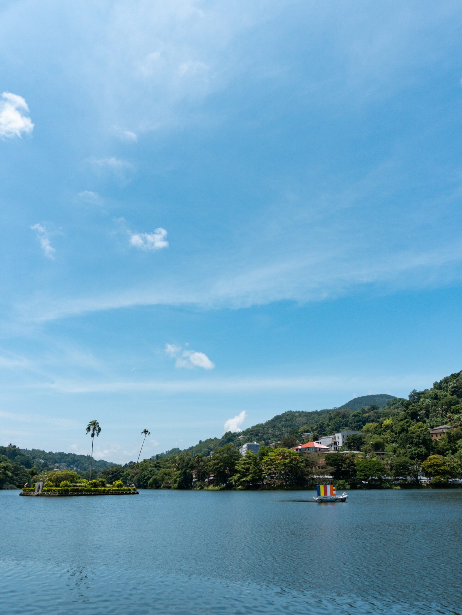 Kandy Lake surrounded by green hills in Sri Lanka, suited to a yoga retreat centered on balance, reflection, and inner change.