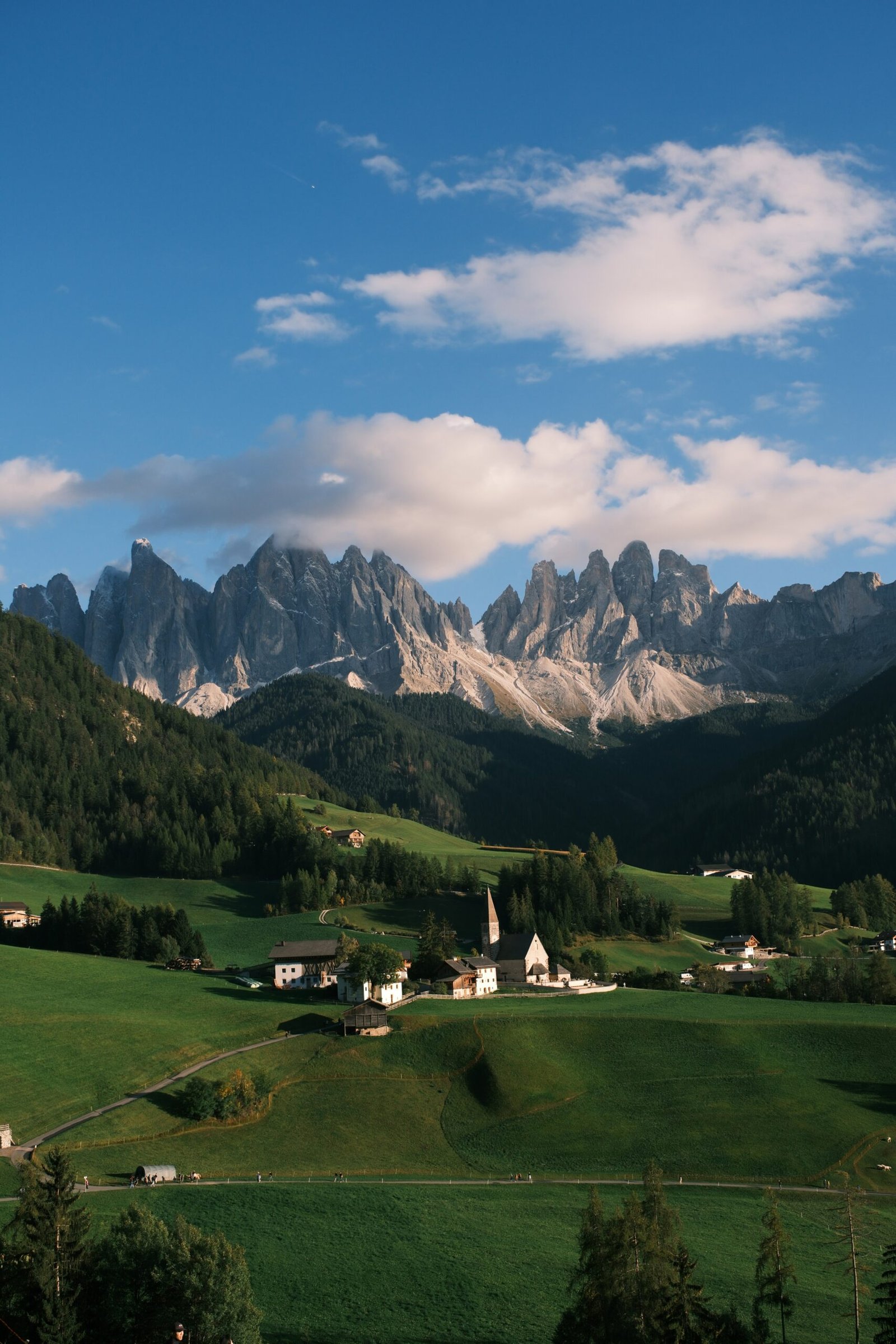 Val di Funes village beneath jagged Dolomite peaks, suited to the article’s quiet pre-winter retreat setting in South Tyrol.