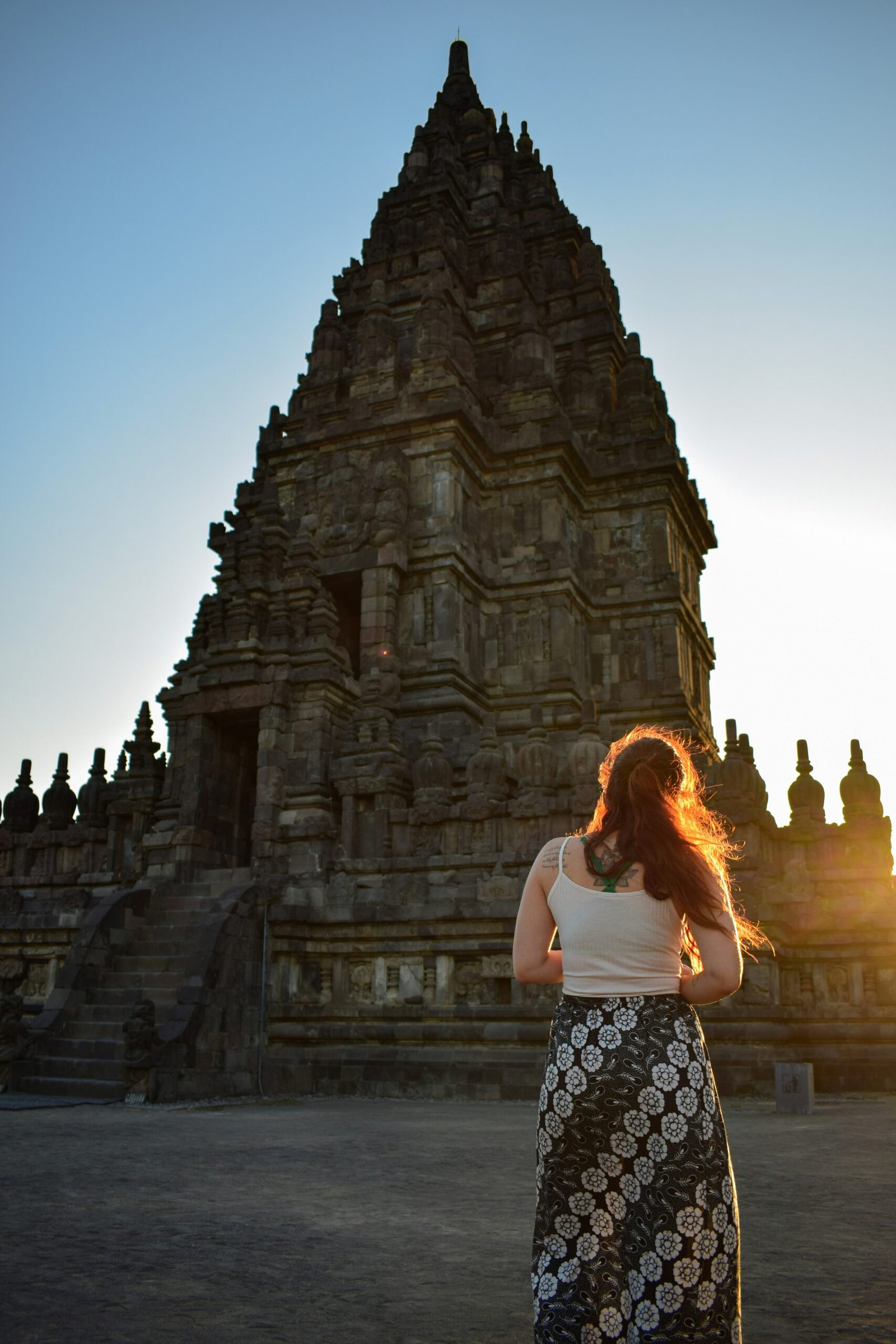 woman holding a yoga pose beside historic temple ruins in thailand