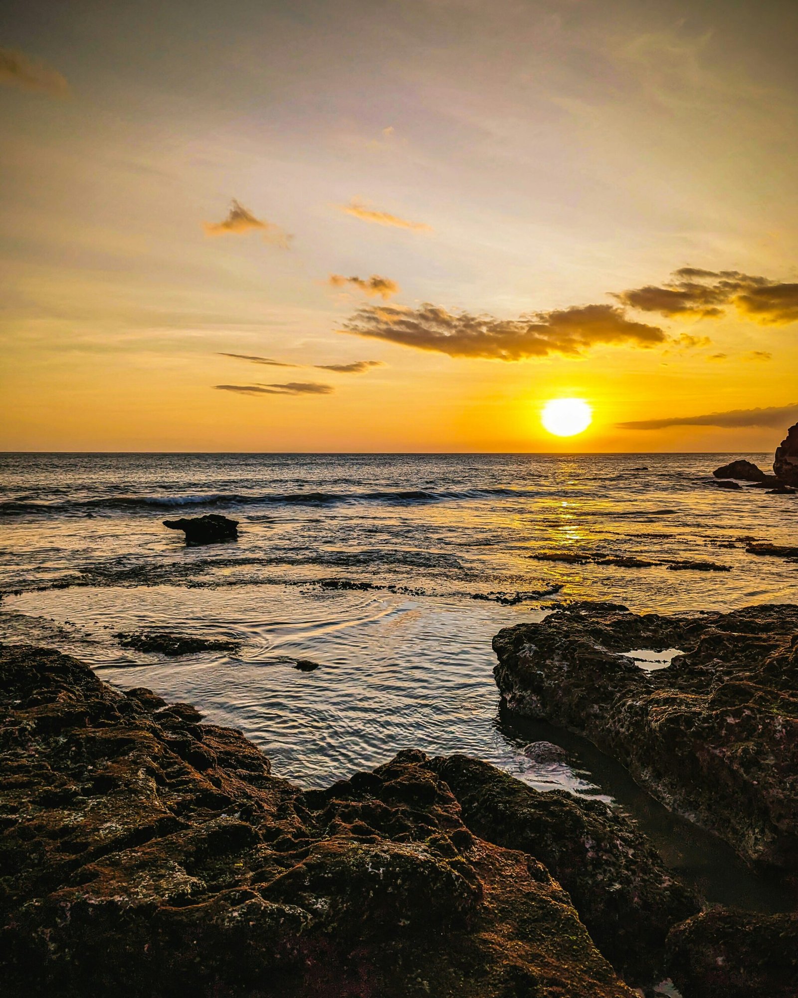 Golden sunset over the rocky shoreline in Nosara, Costa Rica