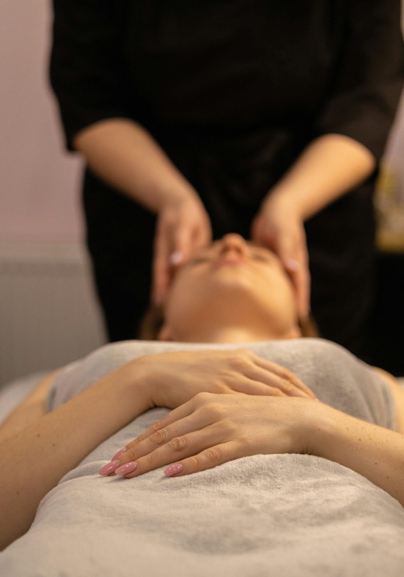 Woman receiving a facial massage at a spa during a relaxing self-care treatment.