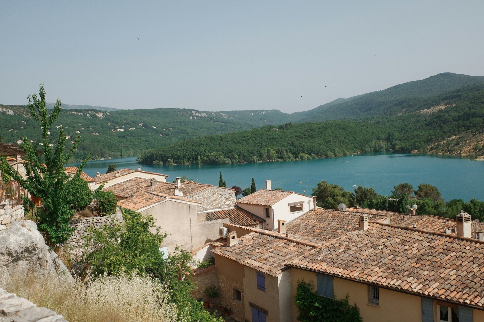 Lakeside village in Bauduen with flowers and warm light, suited to a peaceful France yoga retreat escape.