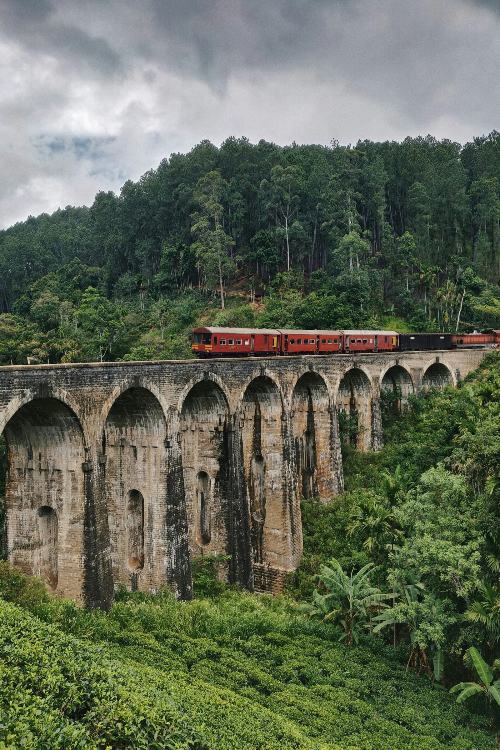 Train crossing Nine Arches Bridge in Ella, Sri Lanka, reflecting the peaceful movement and scenic depth of a hill-country yoga retreat.