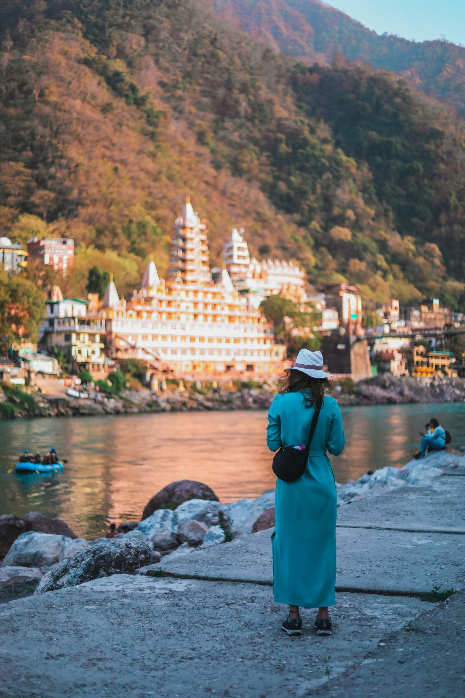Woman standing by the Ganga in Rishikesh, evoking the reflective and spiritual atmosphere of a yoga retreat in northern India.