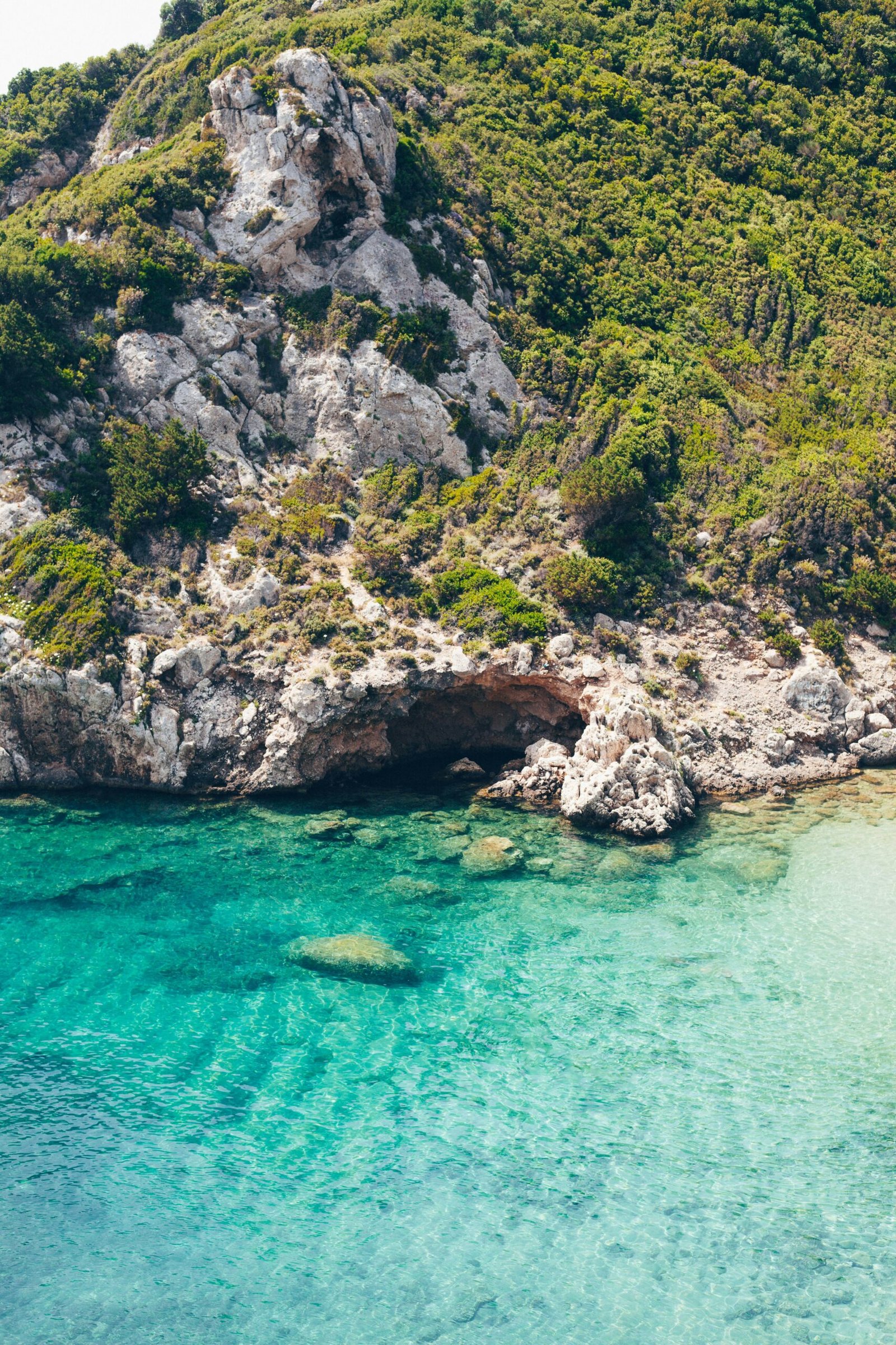 Rocky turquoise coastline in Afionas, Corfu, matching a nature-led May retreat by the sea.