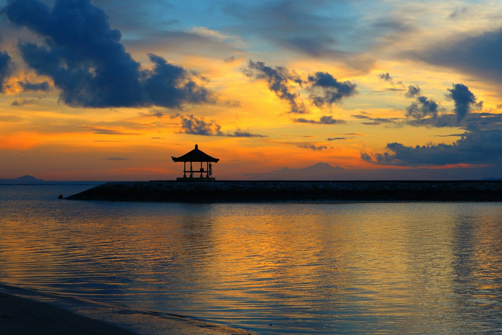 quiet bali shoreline at sunset with warm september skies and calm sea