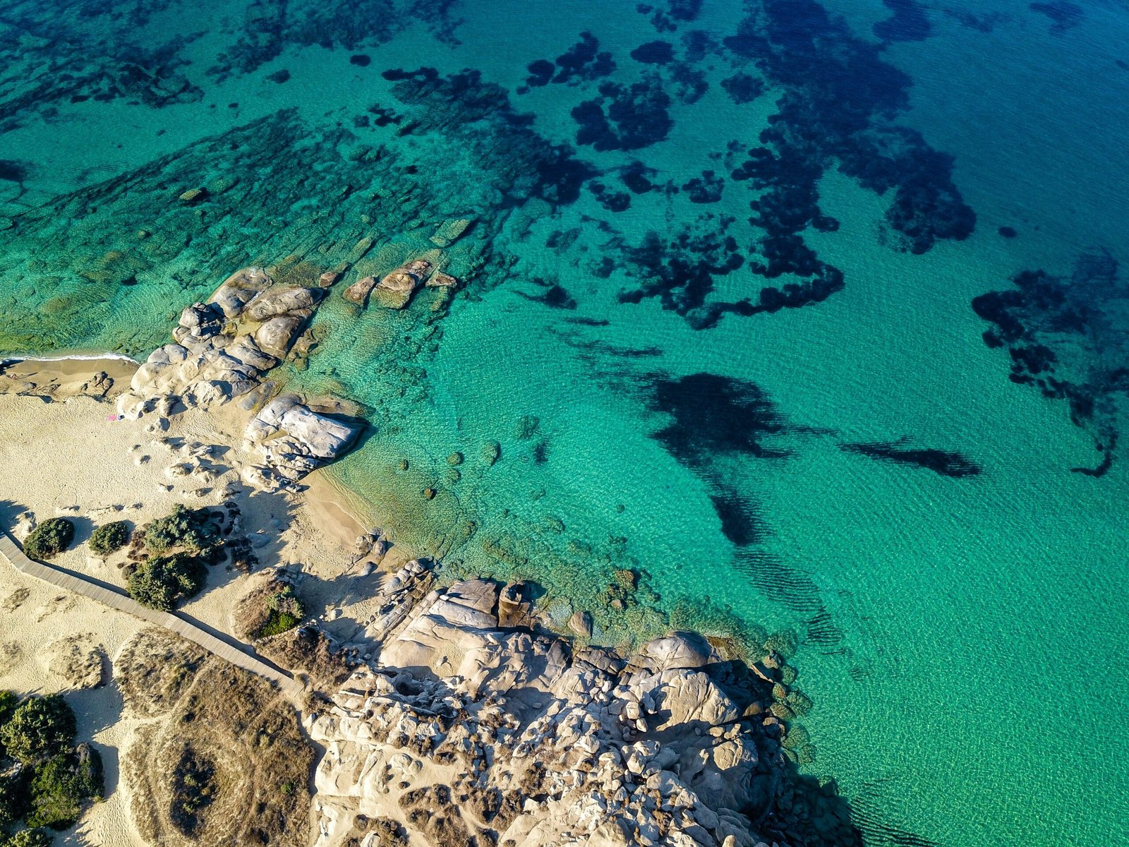 Aerial coastline of Naxos with bright blue sea and open island space suited to a peaceful spring retreat.