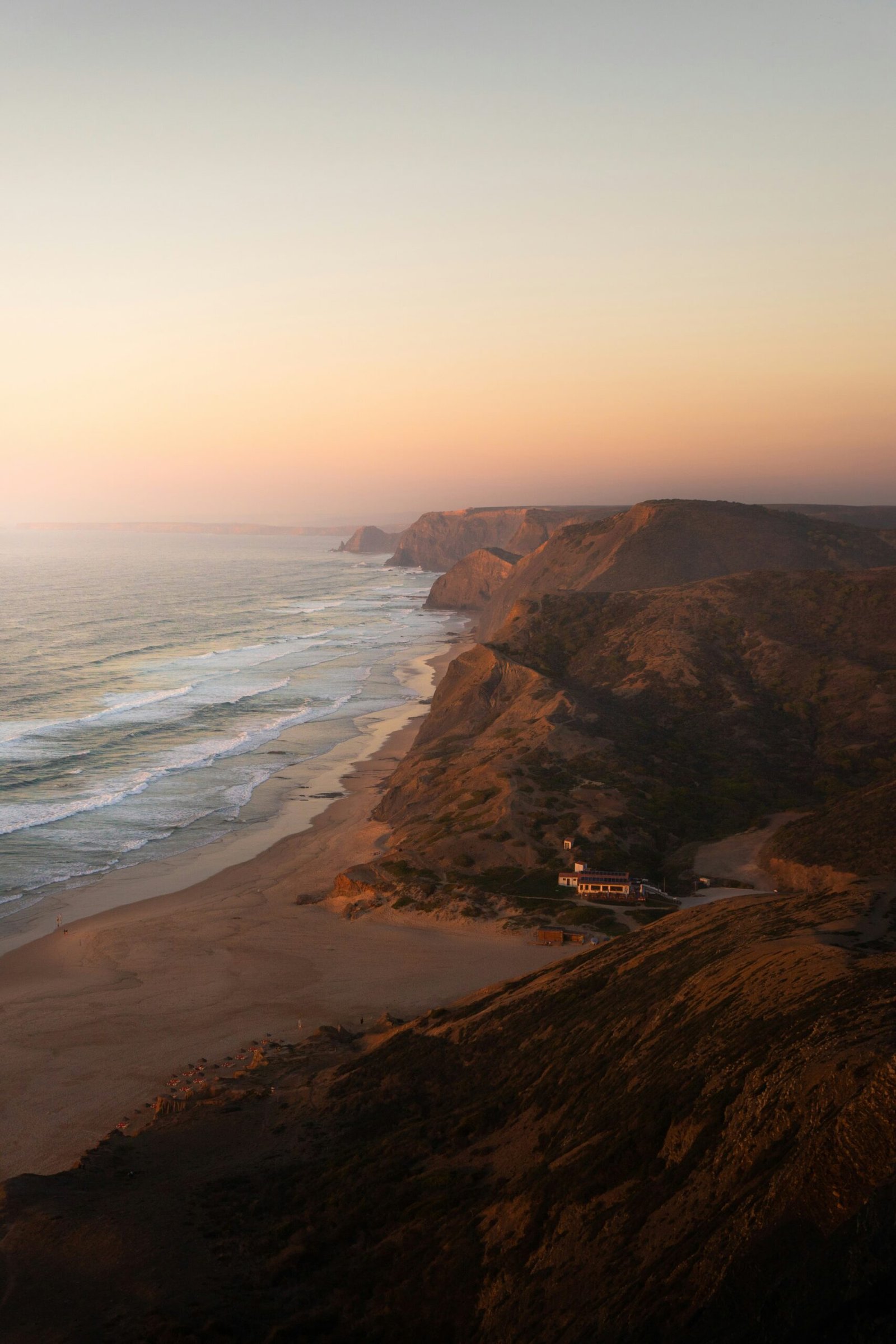 Sunset over the Algarve coast with golden rock formations and a relaxed luxury seaside feel.