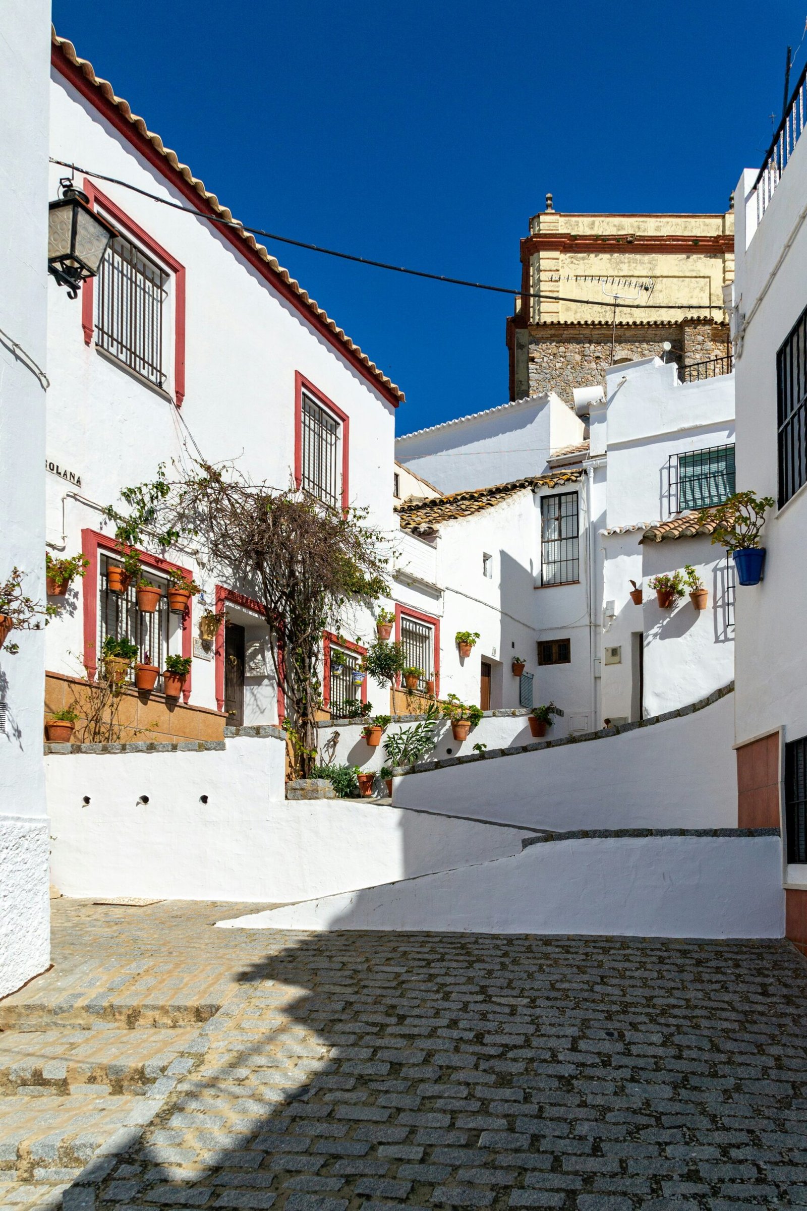 Whitewashed hilltop village of Olvera in Andalusia, Spain, with a fortress and cathedral above the town.