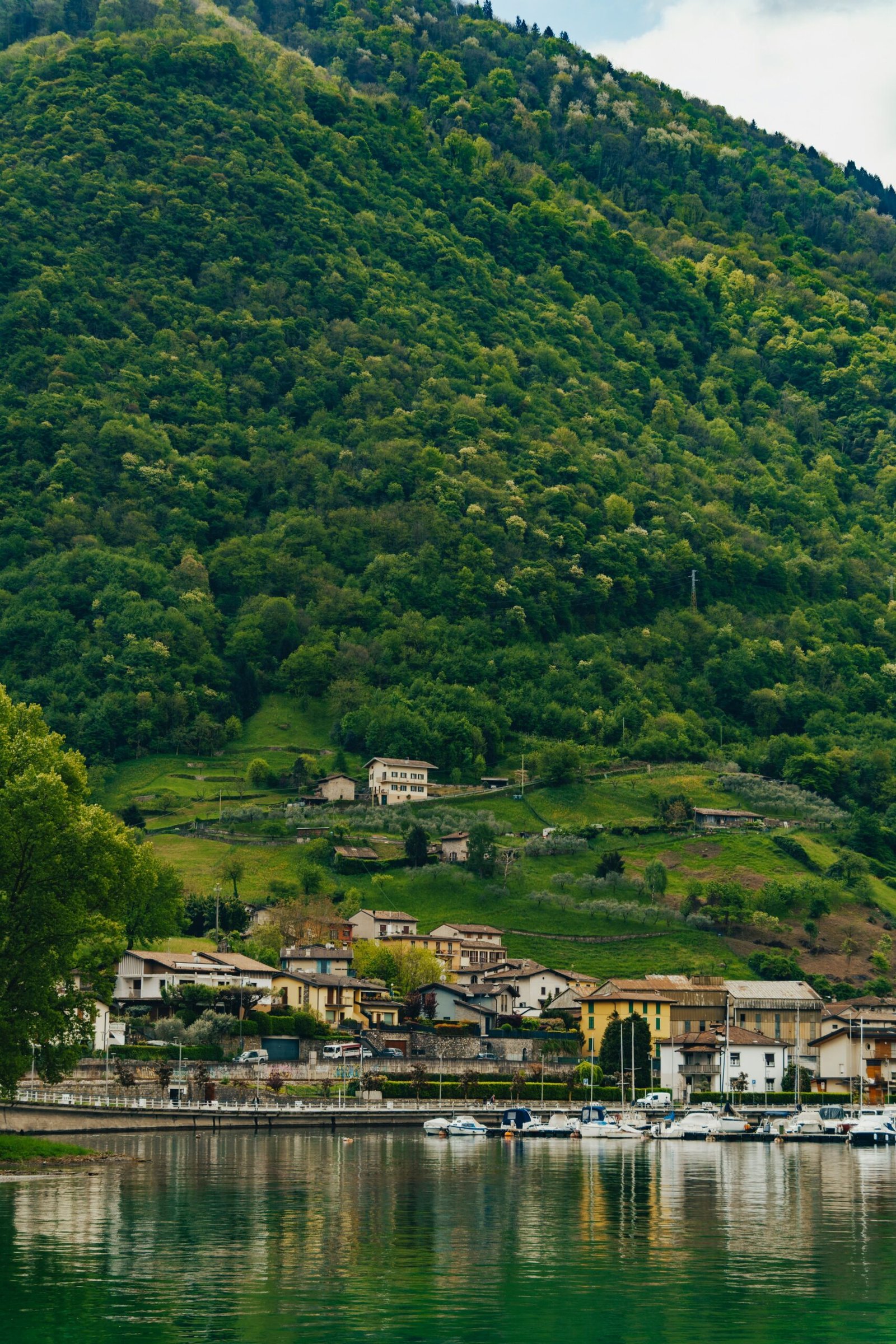 Lakeside village below green hills matching the slow and refreshing atmosphere of a summer Ayurveda retreat