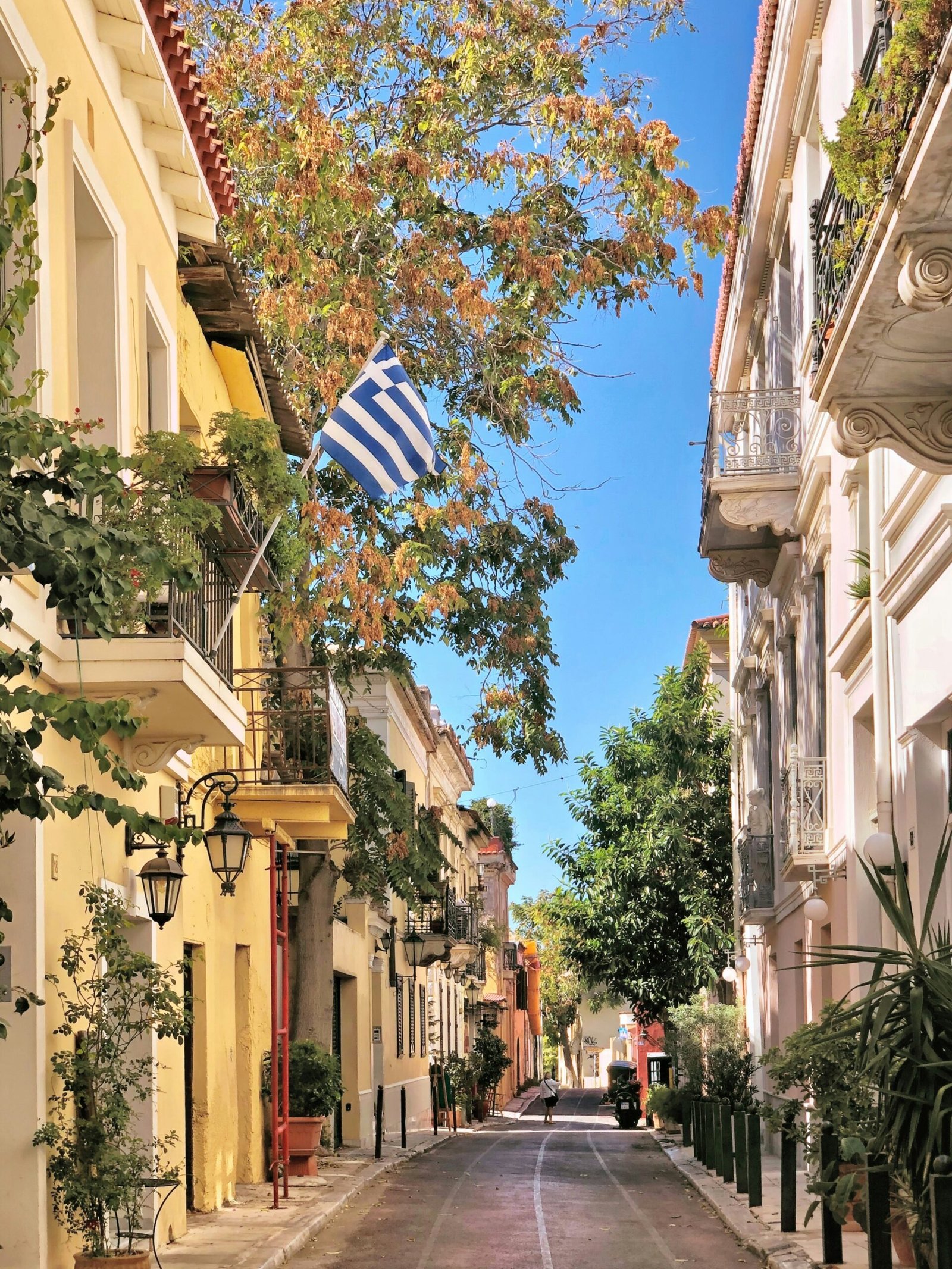 People walking through the streets of Plaka in Athens, creating a cultural city setting that still suits a mindful retreat in Greece.