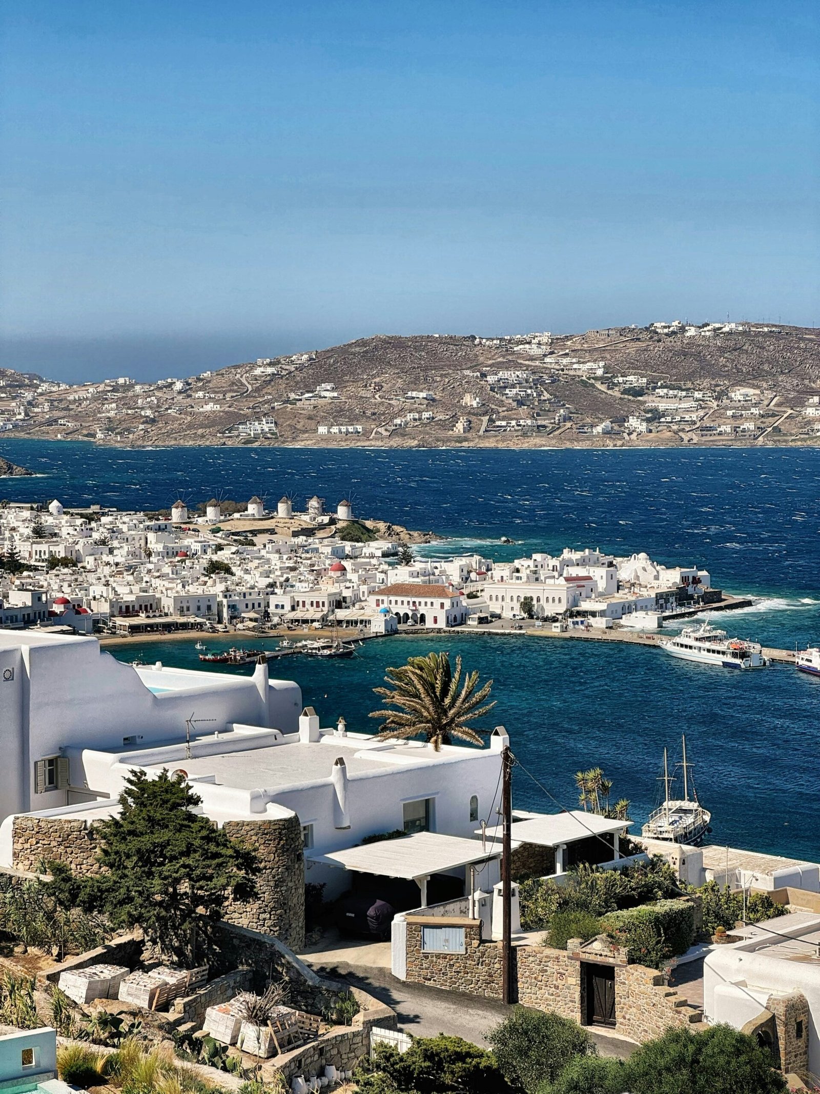 Mykonos town above the sea with whitewashed buildings and a relaxed summer island view.