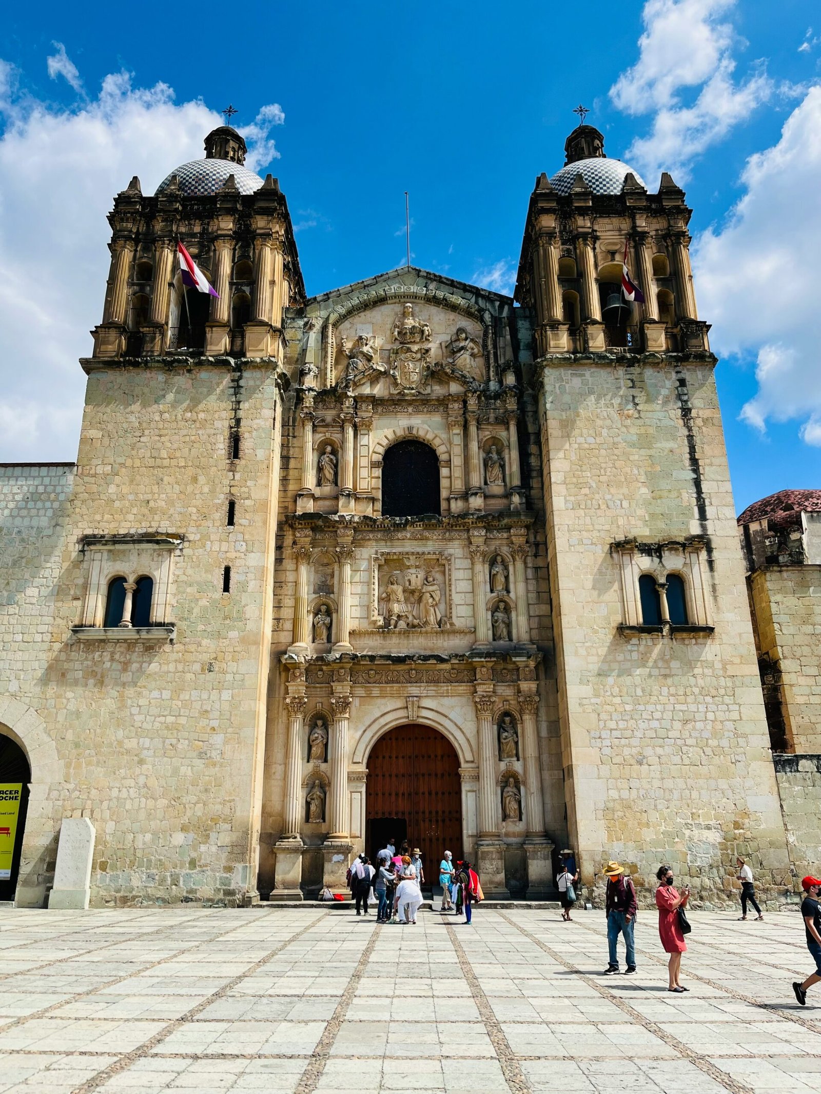 Historic church facade in Oaxaca under a bright blue sky with a grounded cultural feel