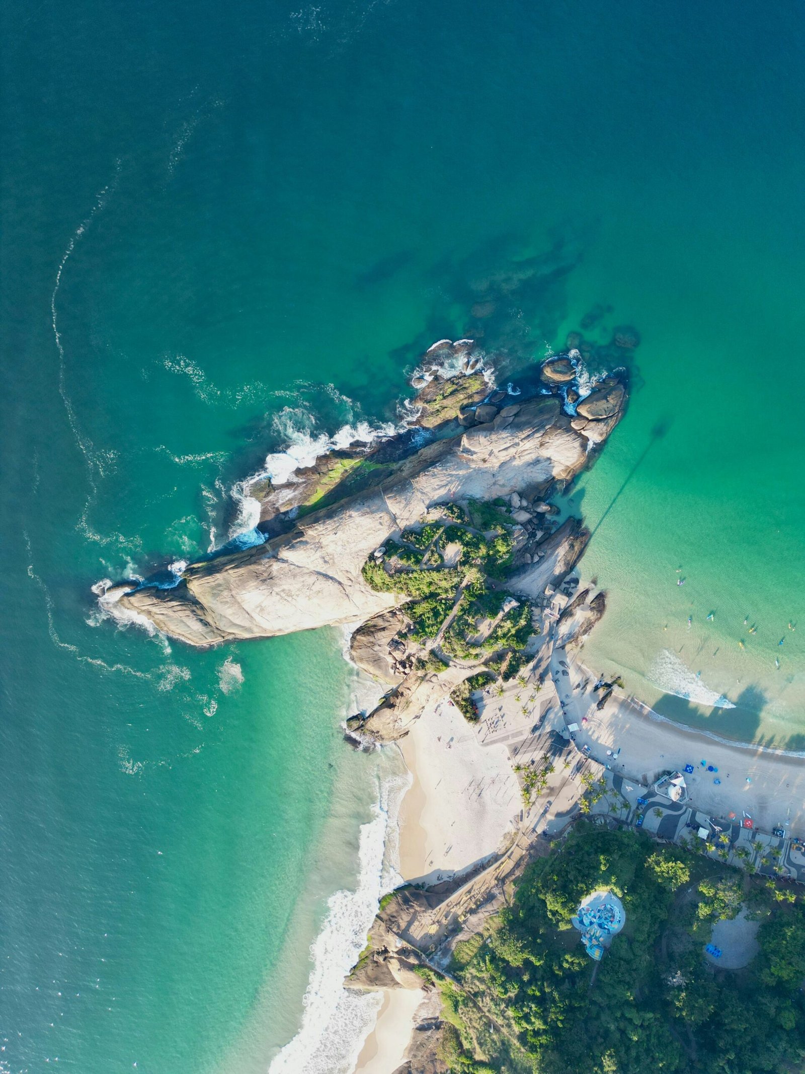Aerial view of Arpoador’s rocky peninsula and surrounding ocean coastline in Rio de Janeiro, Brazil.
