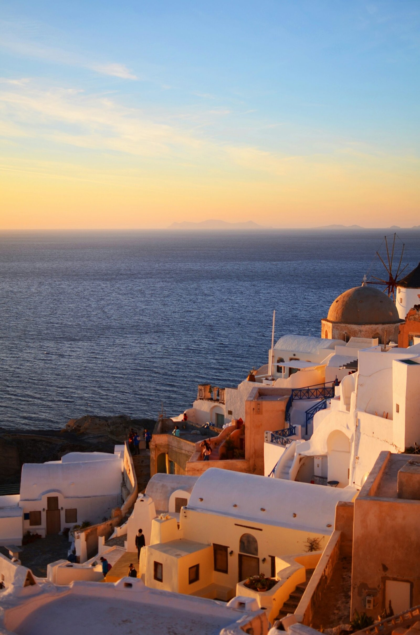Santorini estate at sunset overlooking the sea in Oia, creating a serene and elevated setting for a Greek retreat.