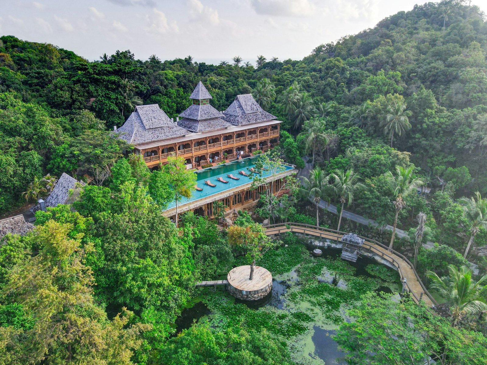 Aerial view of a tranquil wellness retreat resort surrounded by lush tropical forest