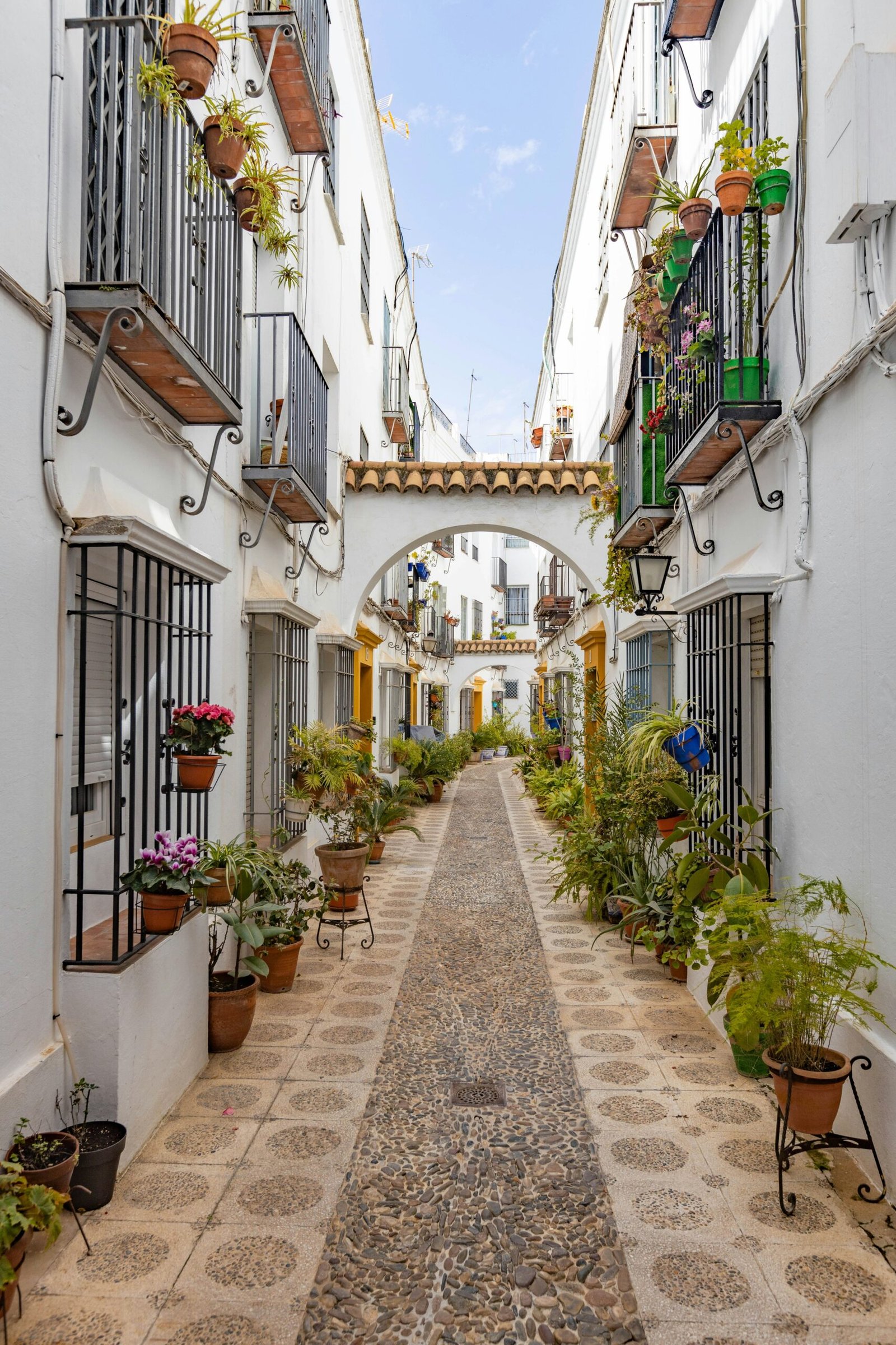 People walking through a historic street in Granada, Spain, with soft light and a lively old-town setting.