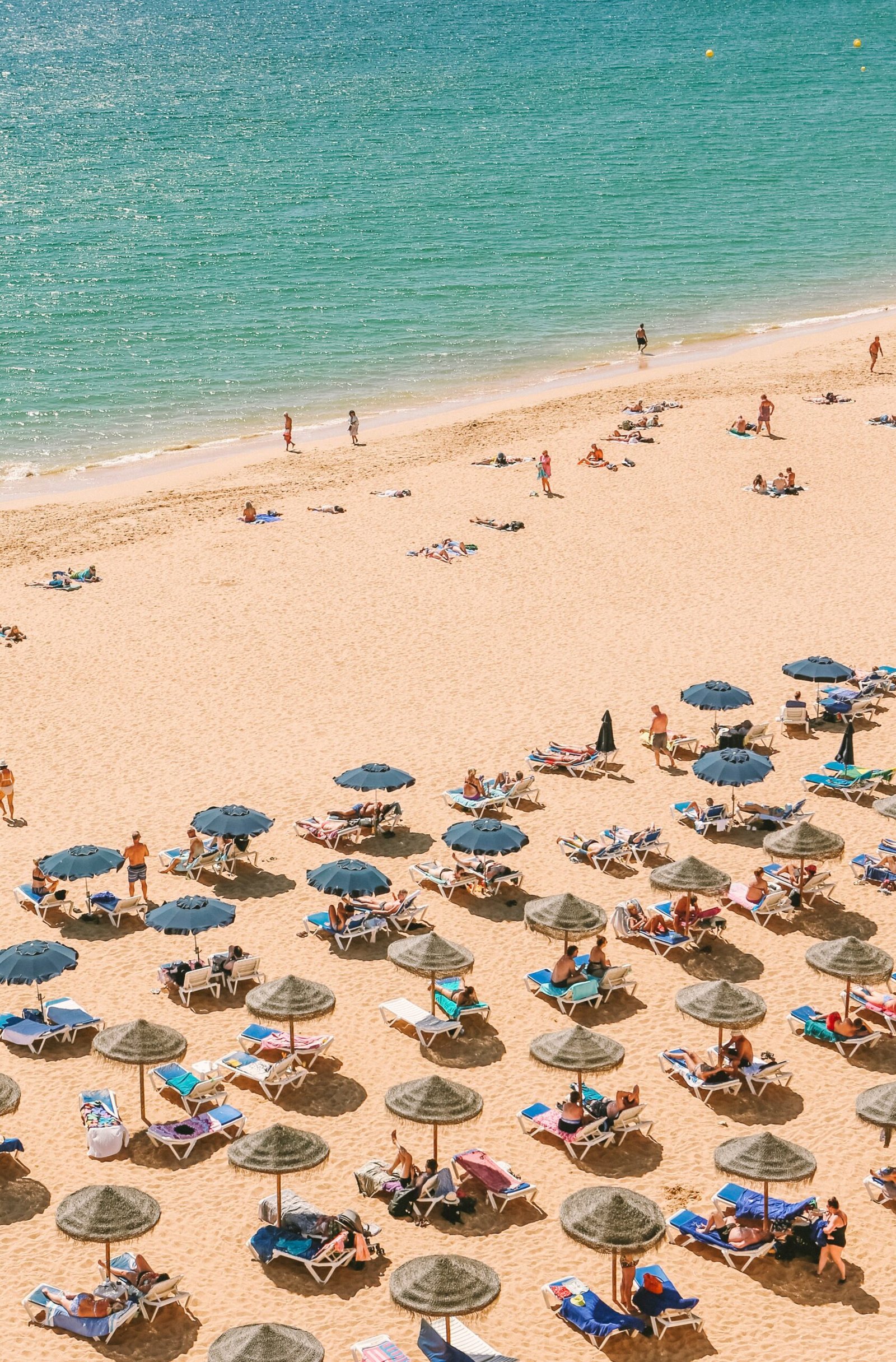 busy summer beach in lagos portugal during the august retreat season
