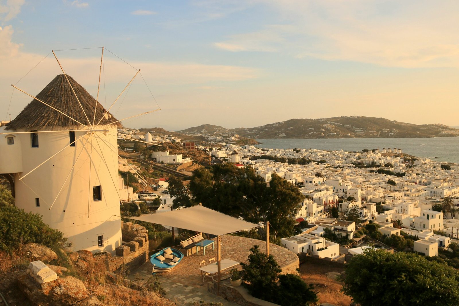White windmill above Mykonos town with sea views and bright Cycladic light.