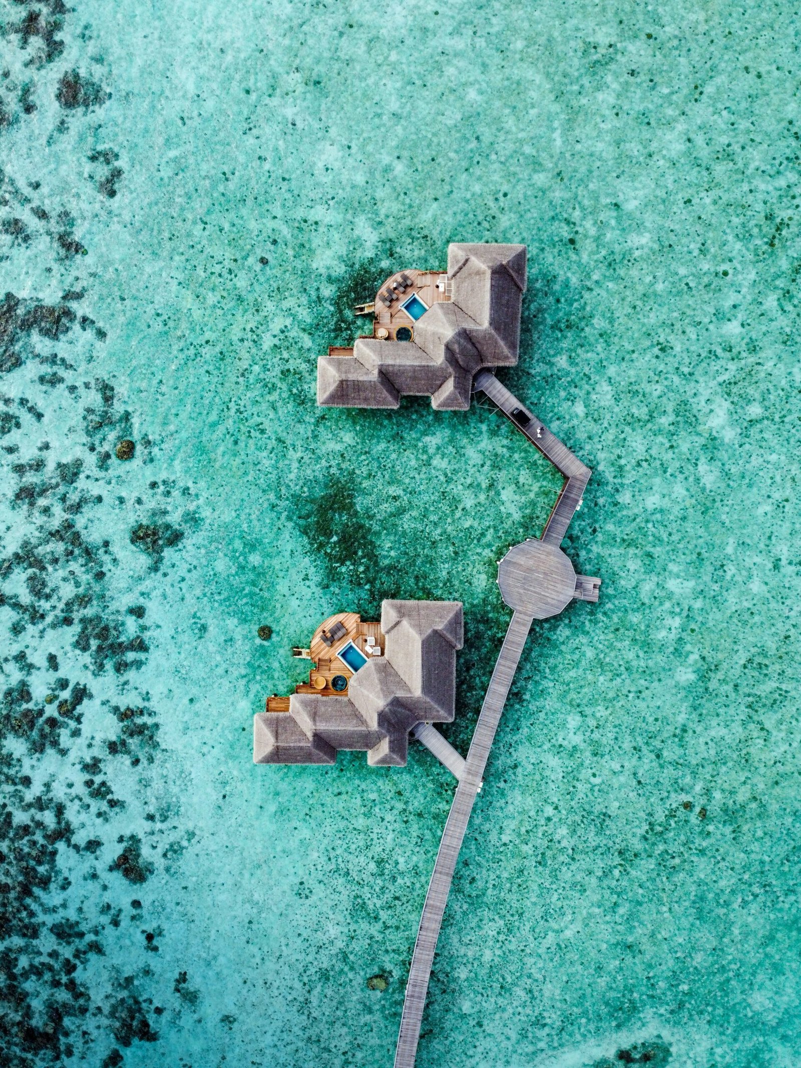 Overwater resort in the Maldives with a bright lagoon and private villa setting.