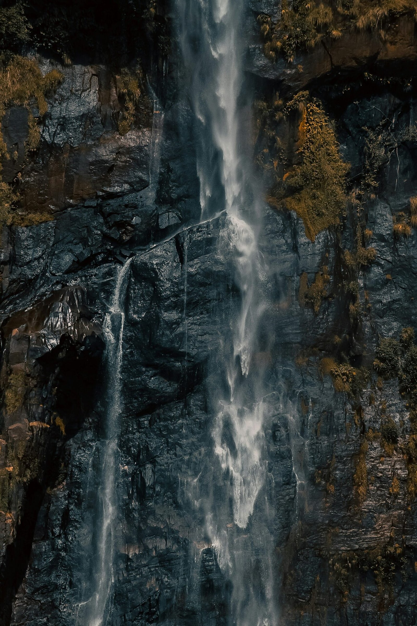 Aerial view of Diyaluma Falls surrounded by forested terrain in Sri Lanka.