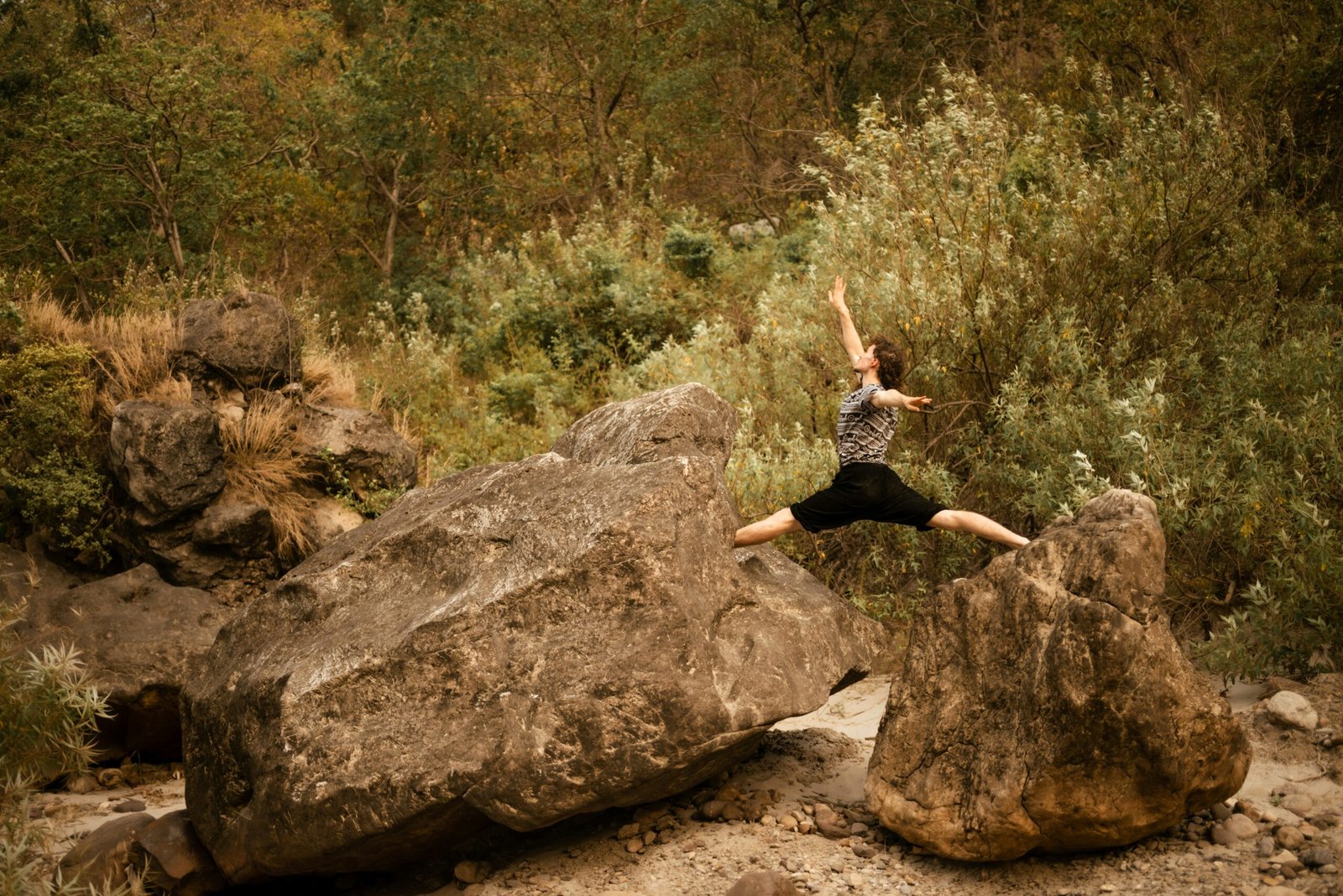 Person leaping above the Ganga in Rishikesh, capturing the uplifting energy and sense of freedom that can shape a retreat in India.