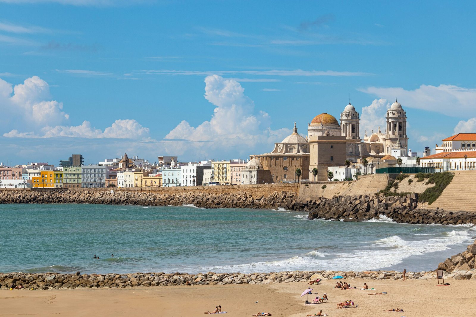 Beachfront view in Cádiz, Spain, with the cathedral rising above the shoreline.