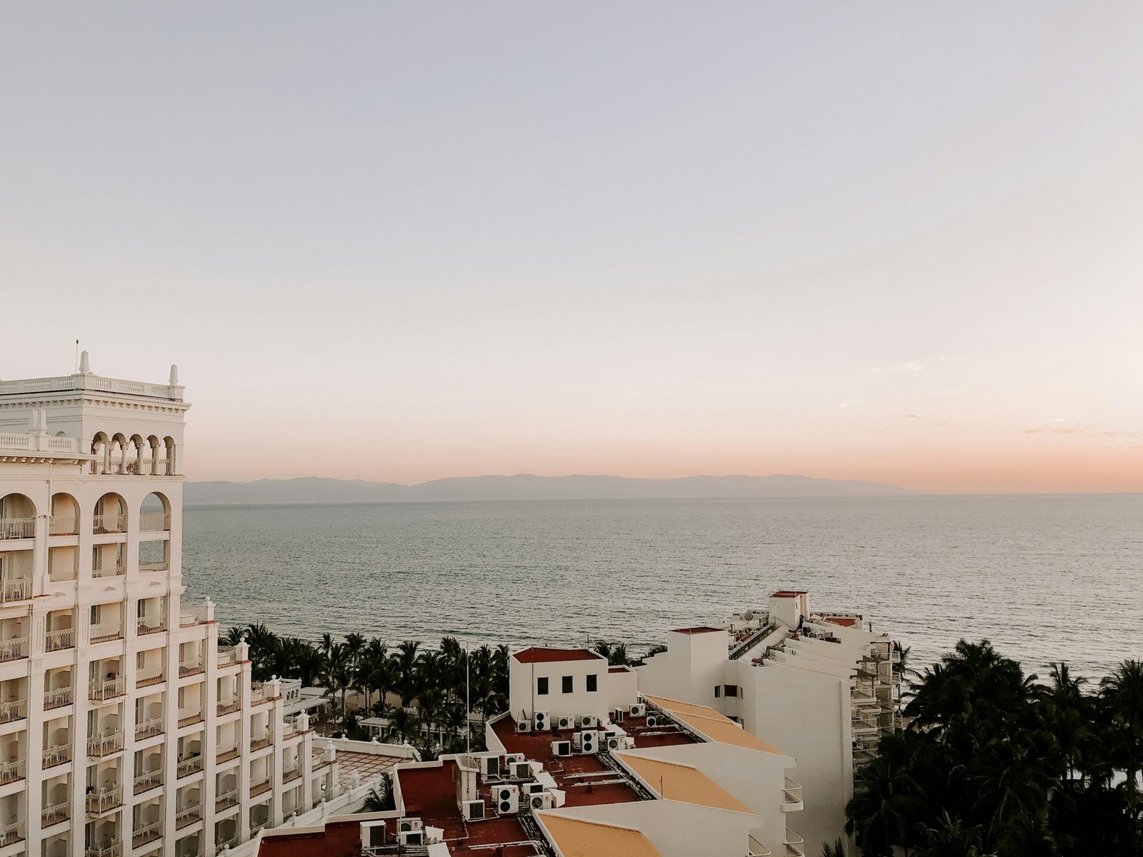 White hillside buildings in Puerto Vallarta surrounded by tropical greenery and coastal light