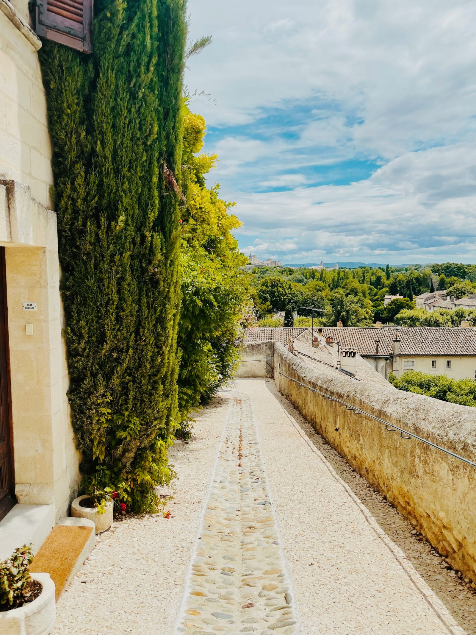 Green garden path beside an old stone wall, suited to a calm and restorative France yoga retreat setting.