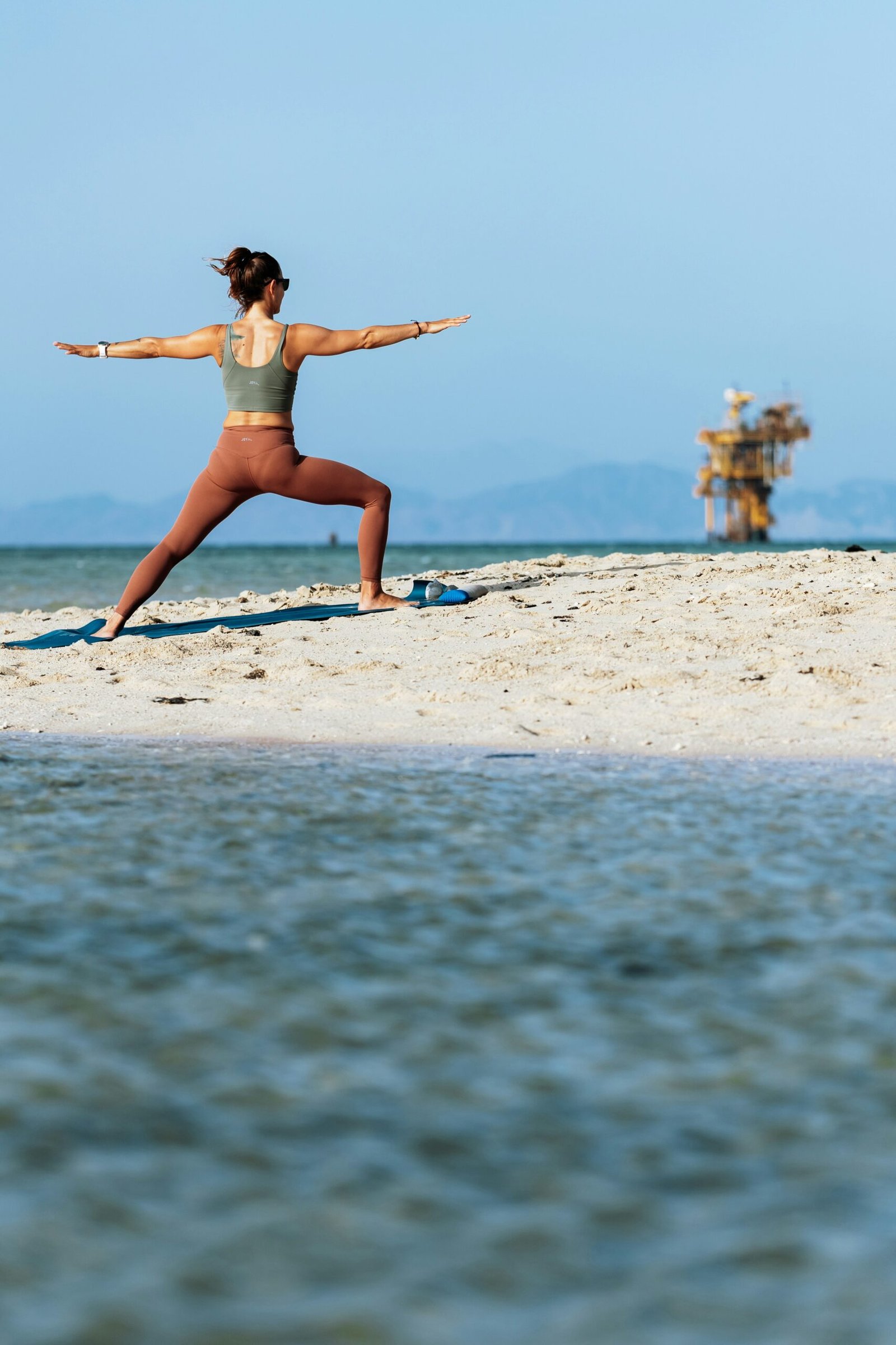 woman practicing yoga by the sea during a march retreat in portugal