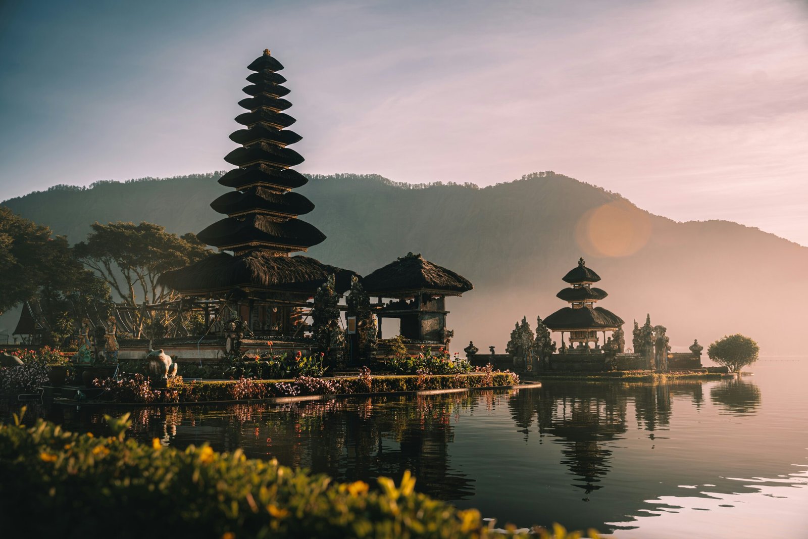 serene balinese temple rising from the water in cool morning mist