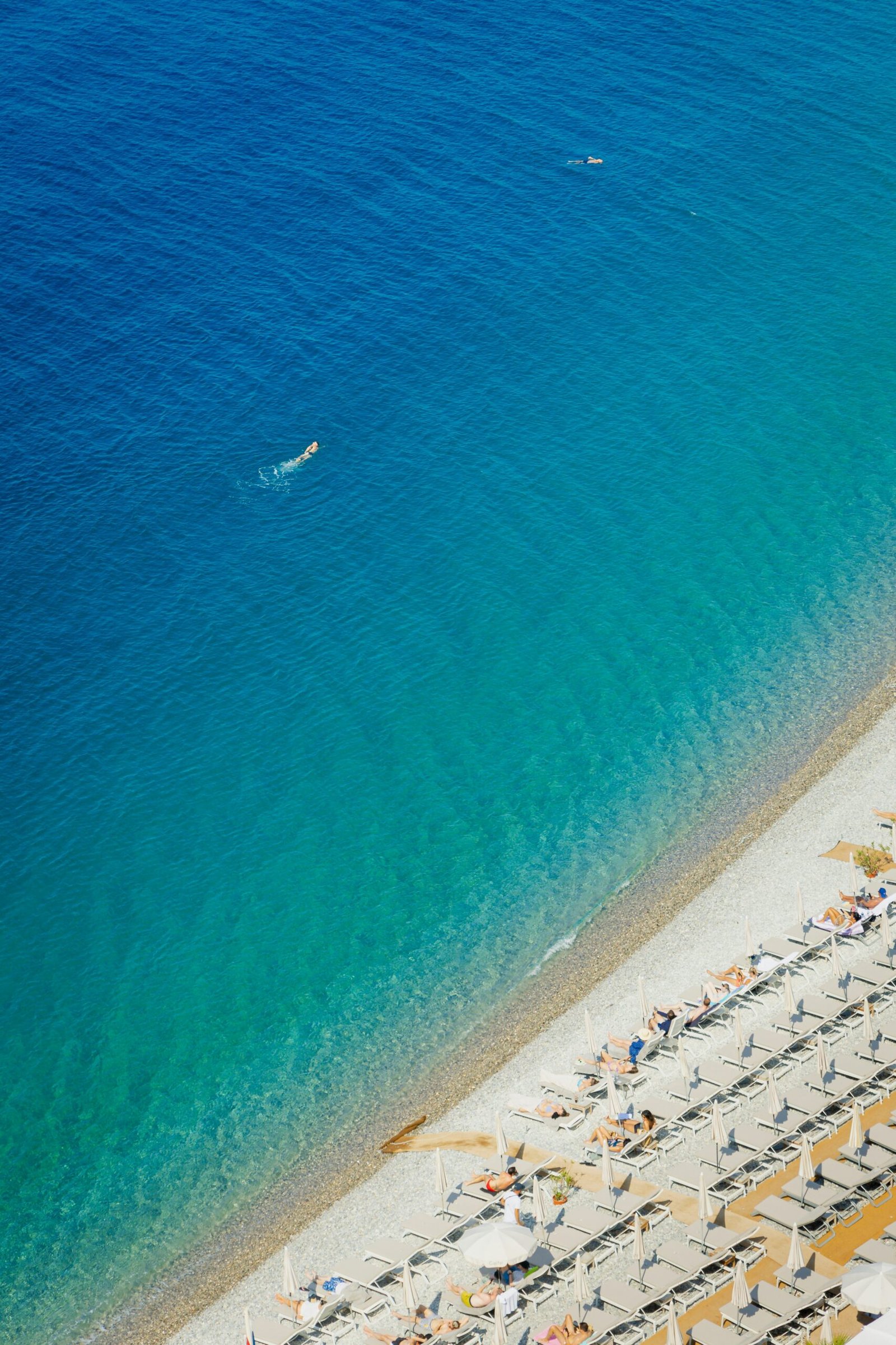 Aerial view of Nice beach and bright Mediterranean water, ideal for a light and energizing France yoga retreat in May.