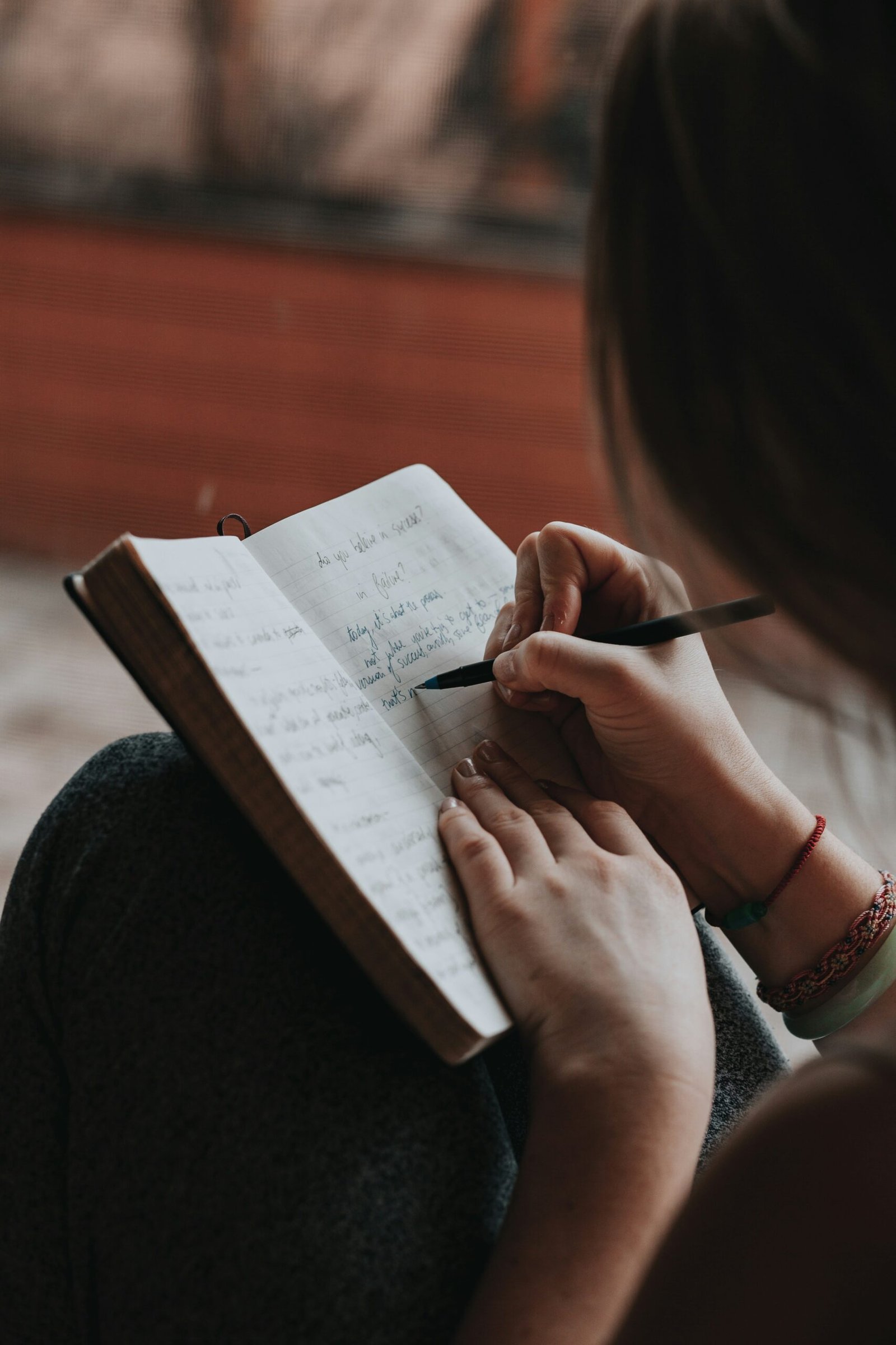 Person writing in a notebook during a quiet reflective journaling moment.