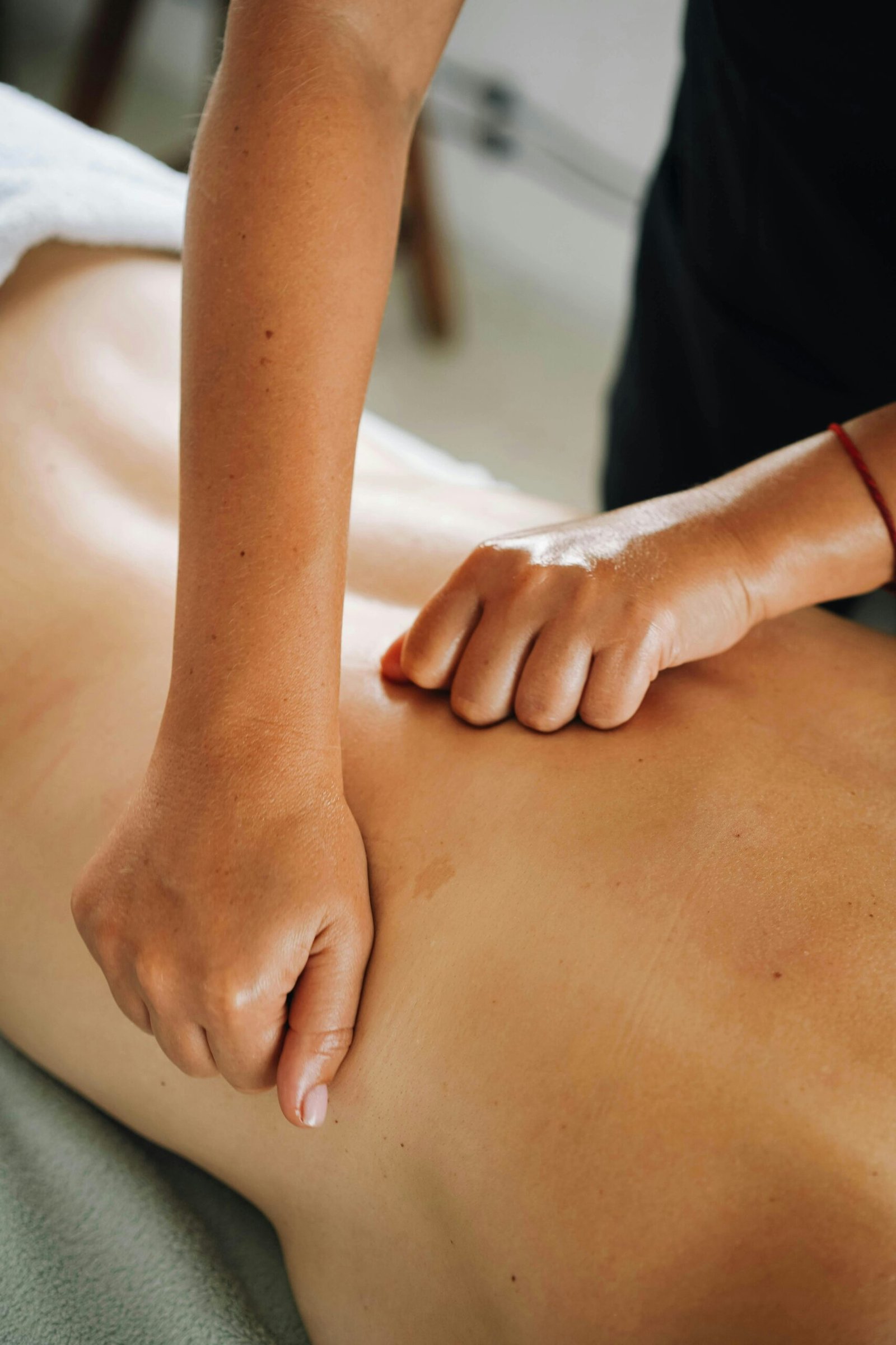 Massage therapist providing a back massage during a relaxing spa treatment.