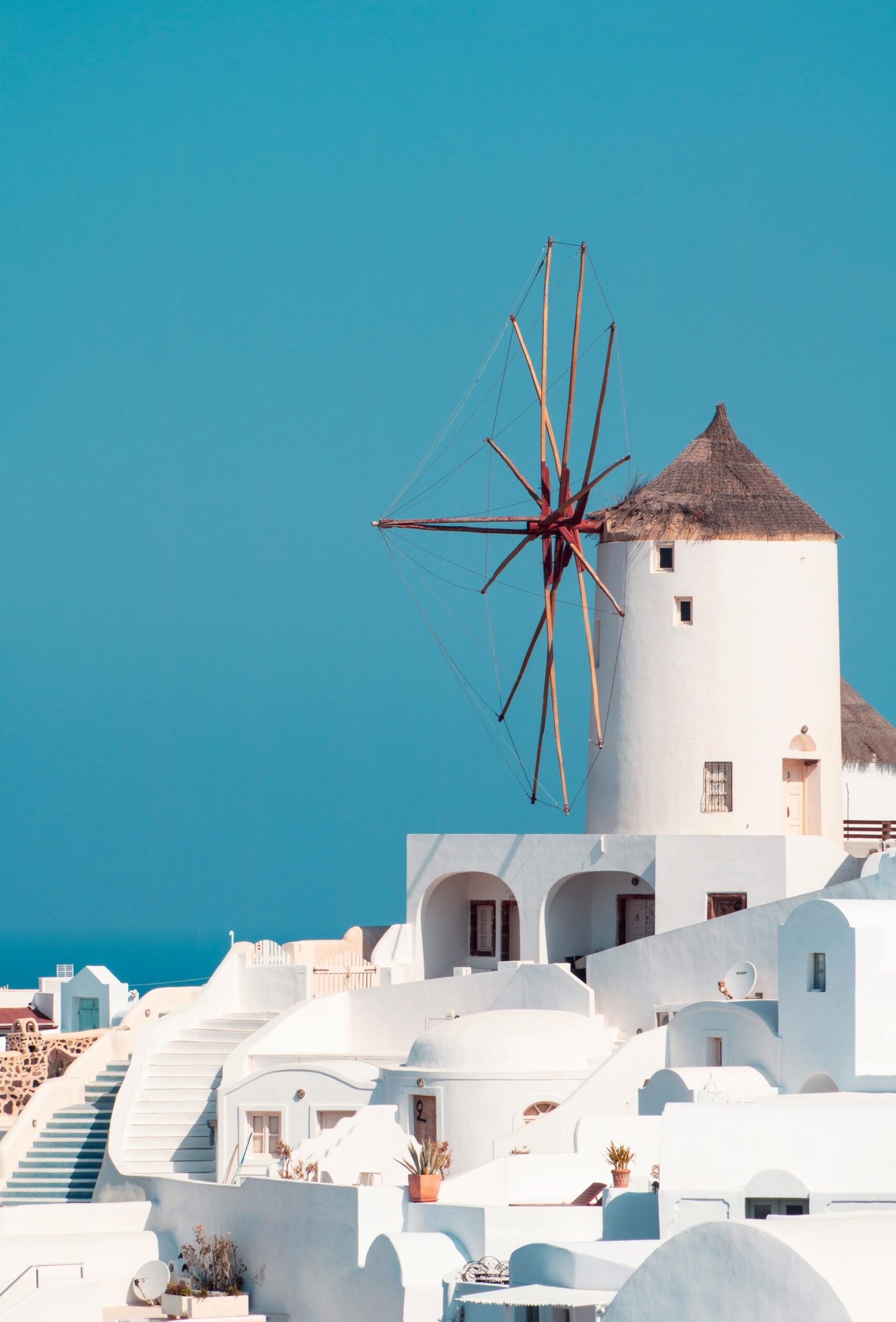 Traditional windmill in Oia, Santorini, bringing a peaceful island atmosphere to a Greece retreat stay.