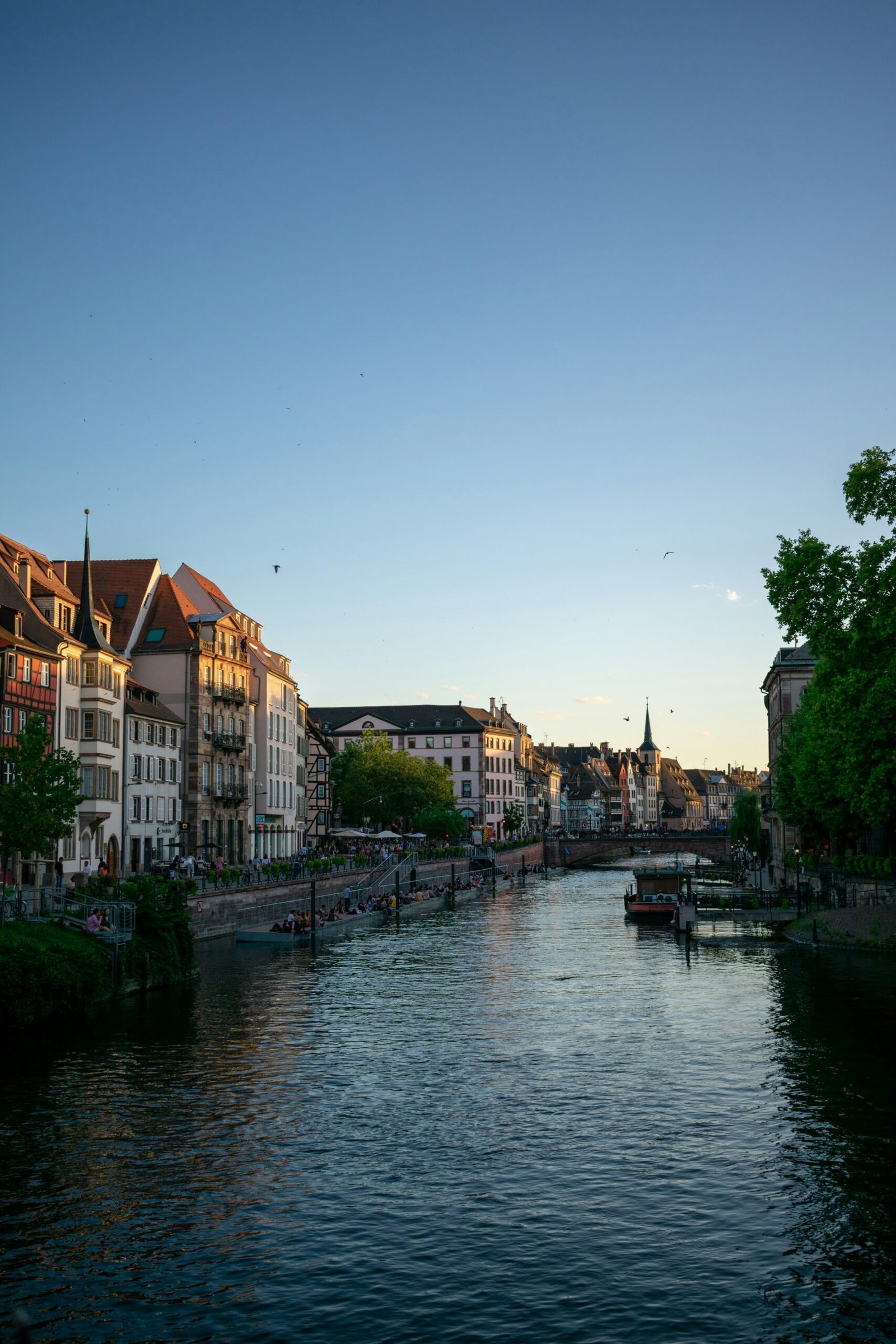 River view through historic Strasbourg buildings at sunset, creating a calm and scenic backdrop for a France yoga retreat.