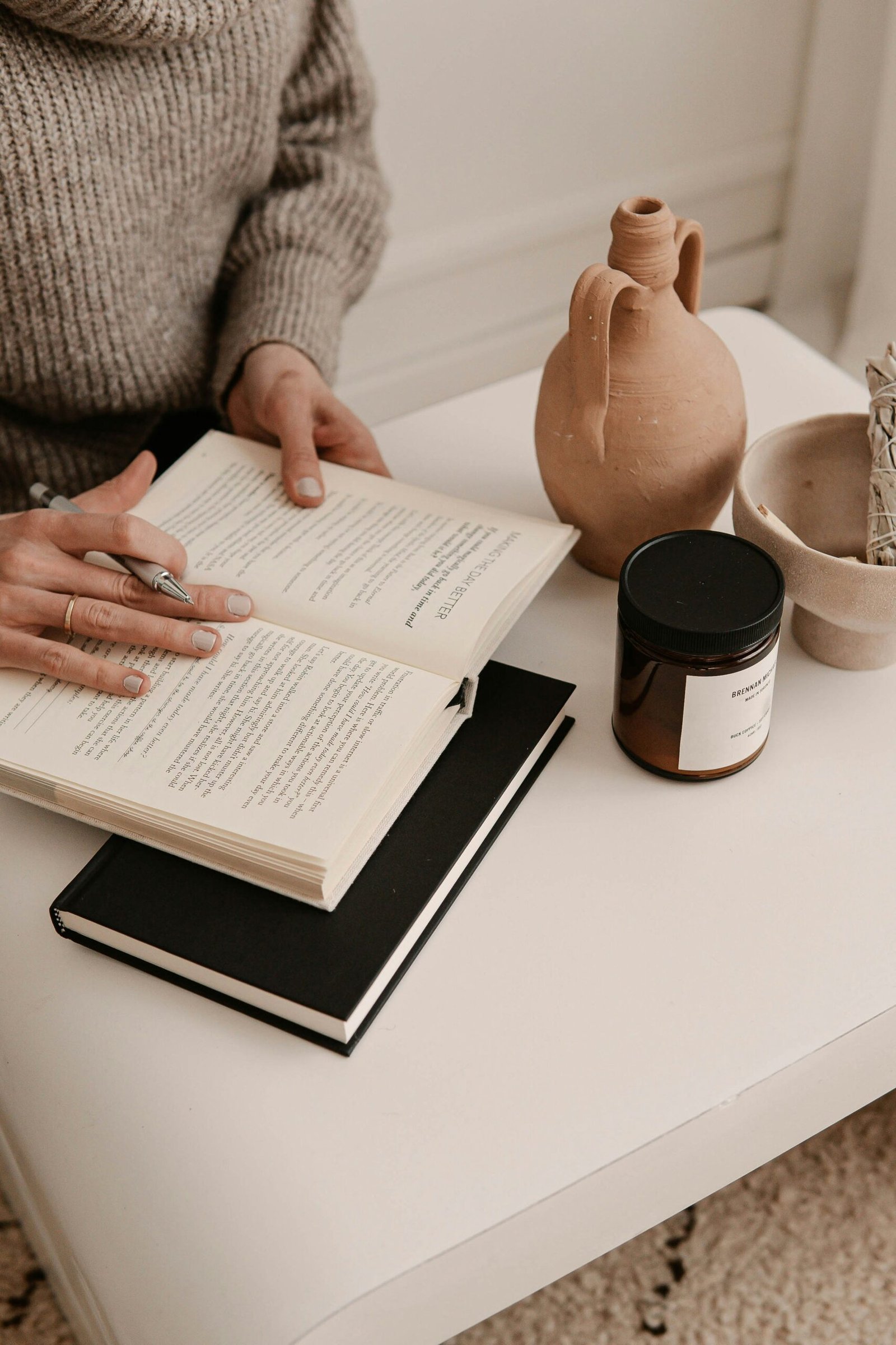 Person in a gray sweater holding a sheet of paper in a quiet wellness setting, suited to retreat journaling or reflection.