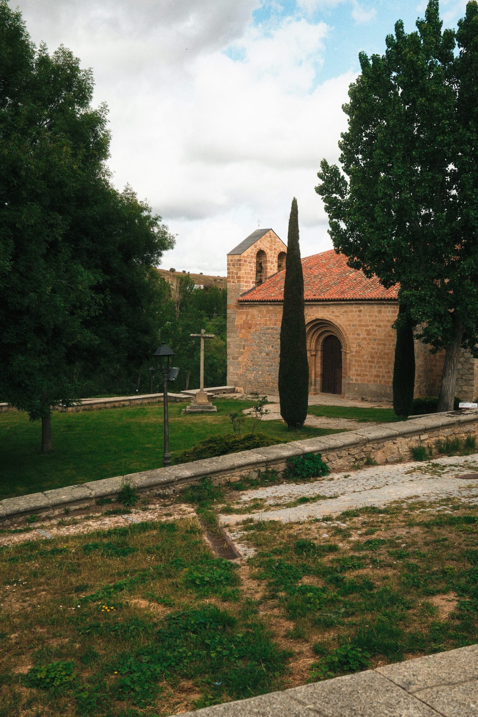Church with a clock tower in a green park in Ávila, Spain.