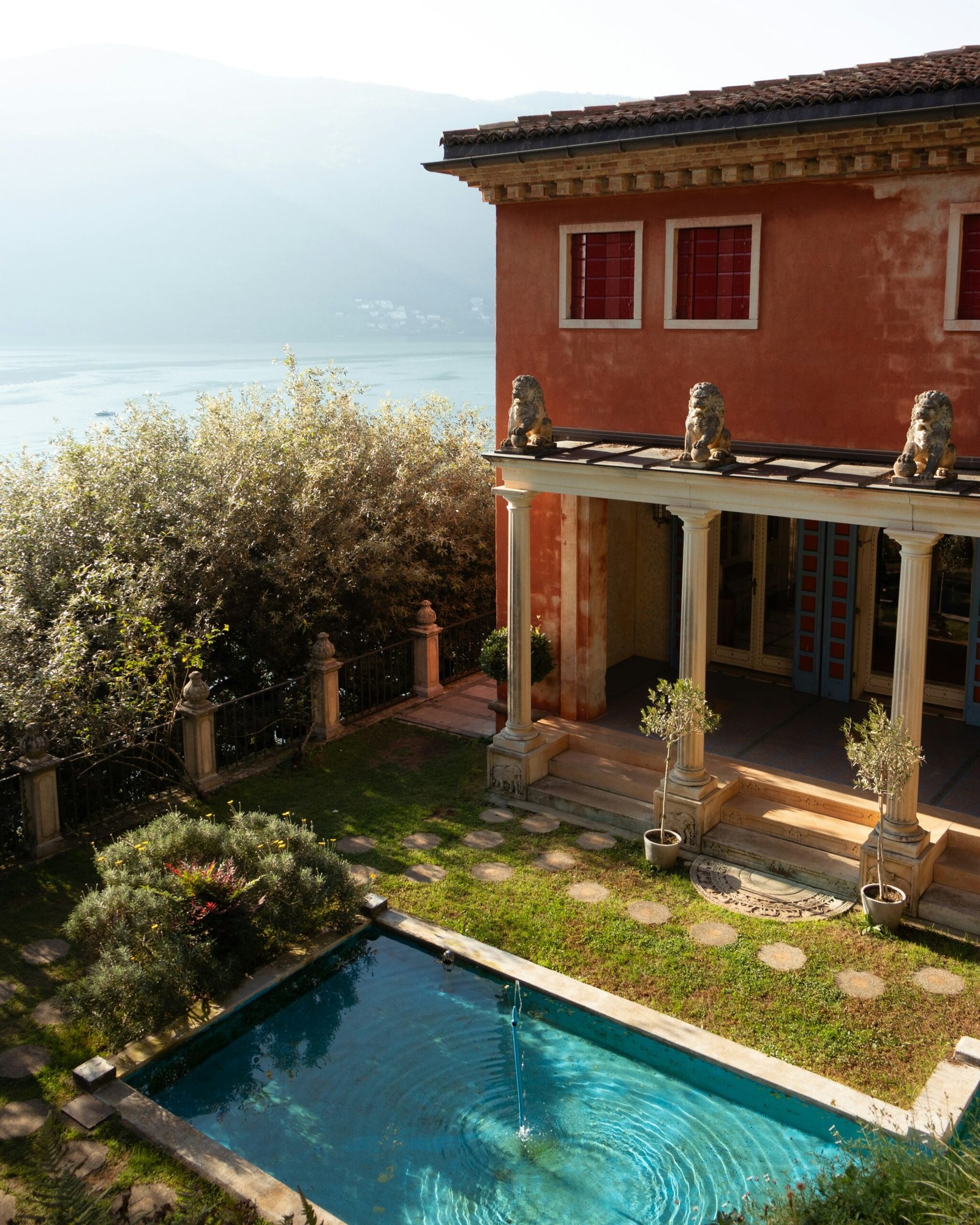 Poolside villa surrounded by garden greenery in Italy, reflecting the calm and luxurious setting of a wellness retreat.
