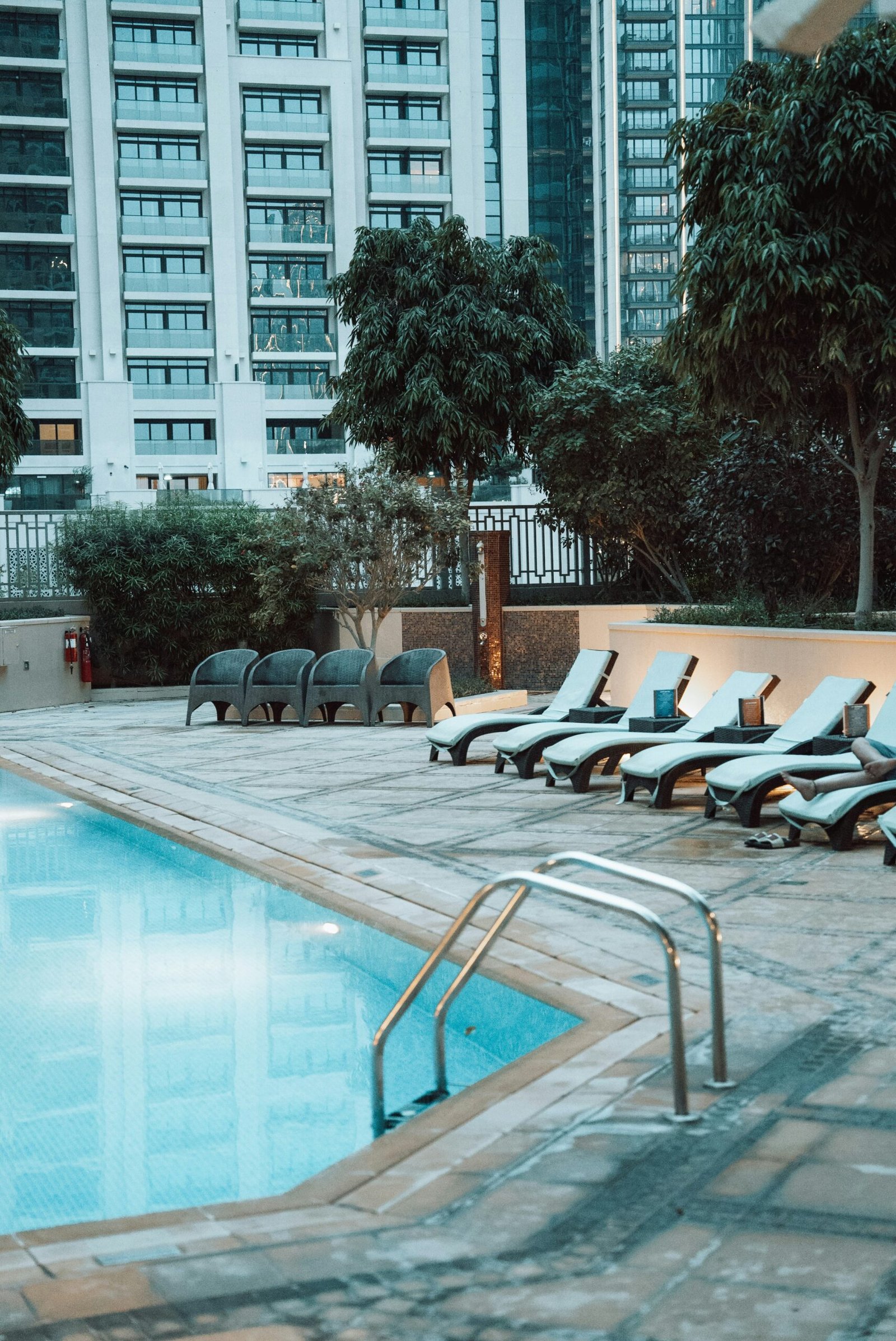 Swimming pool with lounge chairs in a modern spa-style hotel setting.