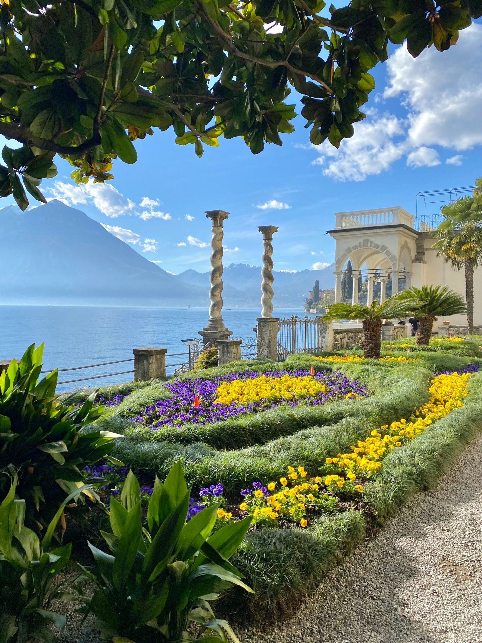 Villa Monastero garden in Varenna overlooking Lake Como with flowers and soft spring greenery.