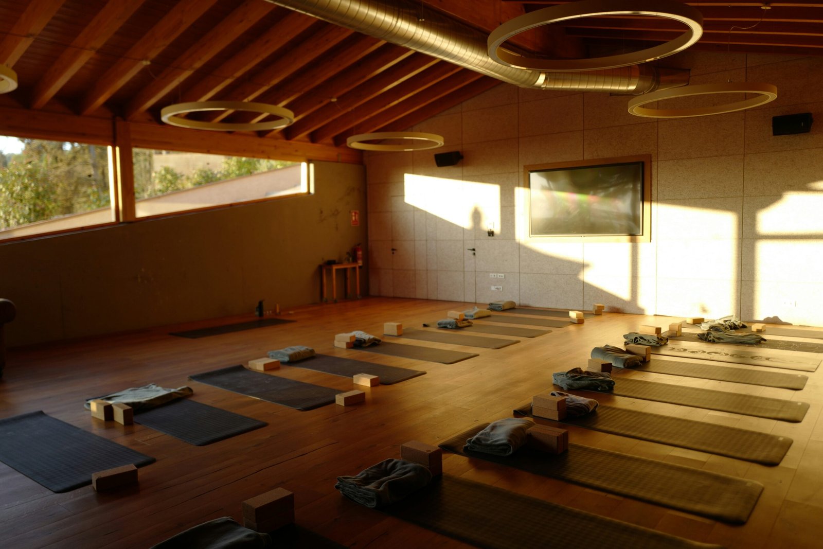 Spacious indoor yoga studio with neatly arranged mats set up for a group retreat session.