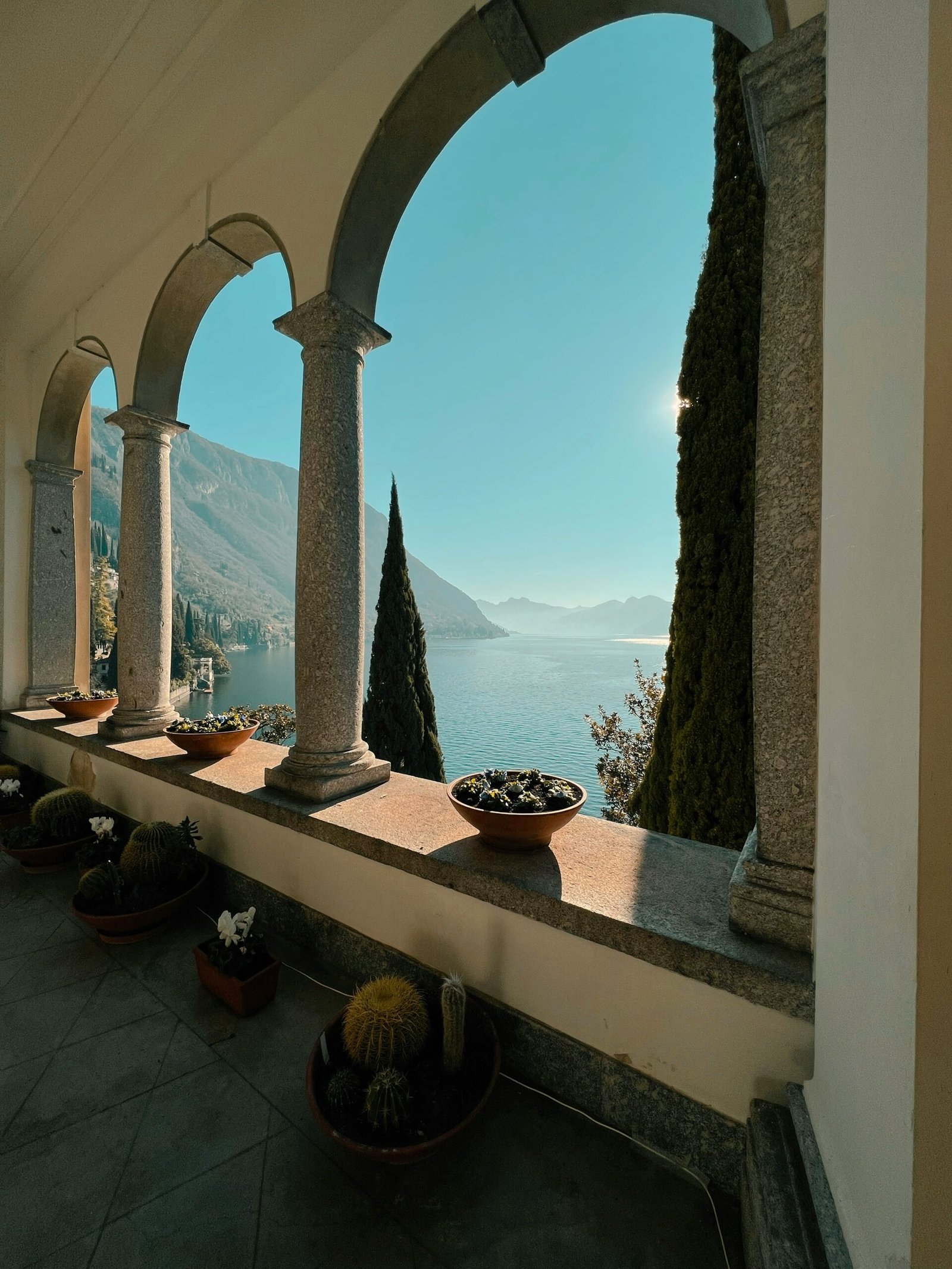 Row of potted plants on a Lake Como balcony in Italy, matching the serene outdoor spaces of a restorative retreat.