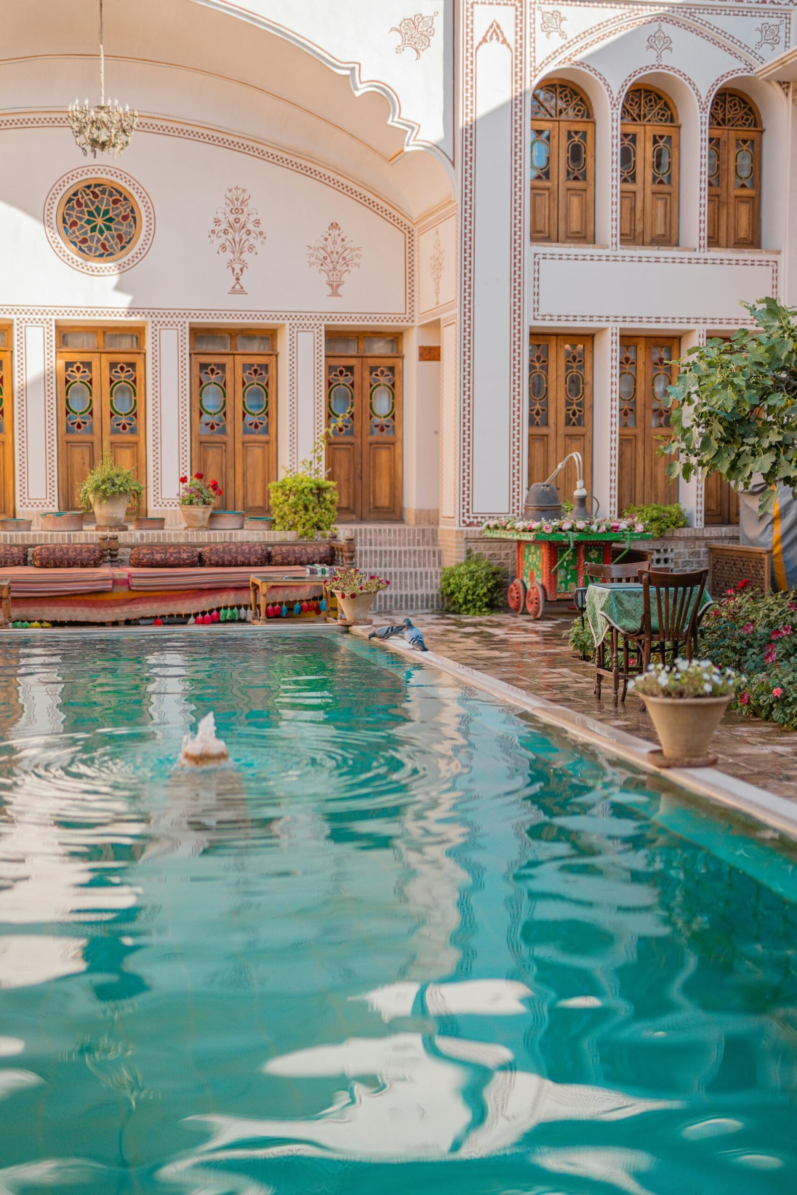 ornate riad courtyard in marrakesh with pool and cooling shade
