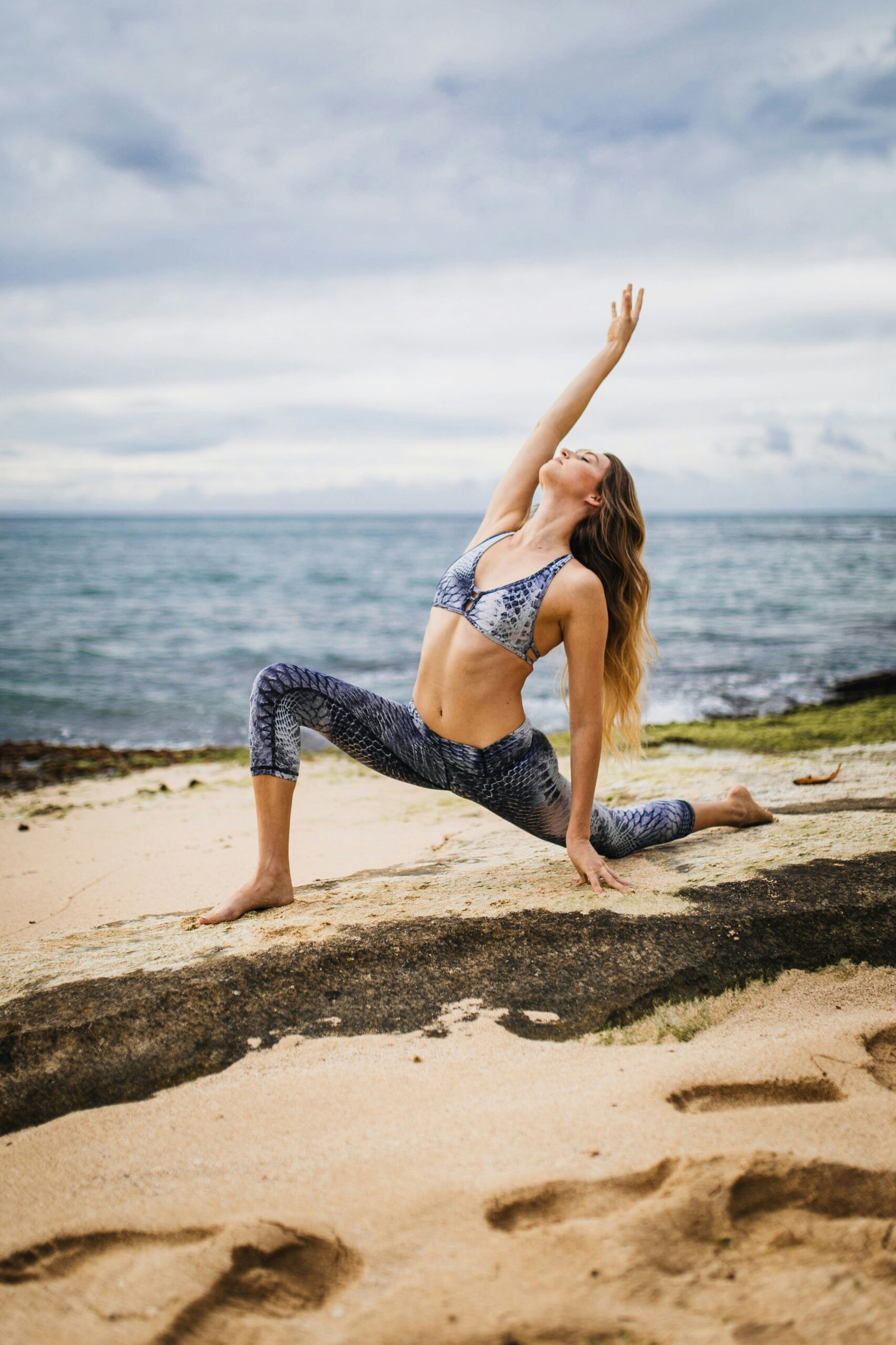 Woman practicing yoga on a quiet beach at sunrise during a Thailand spring retreat