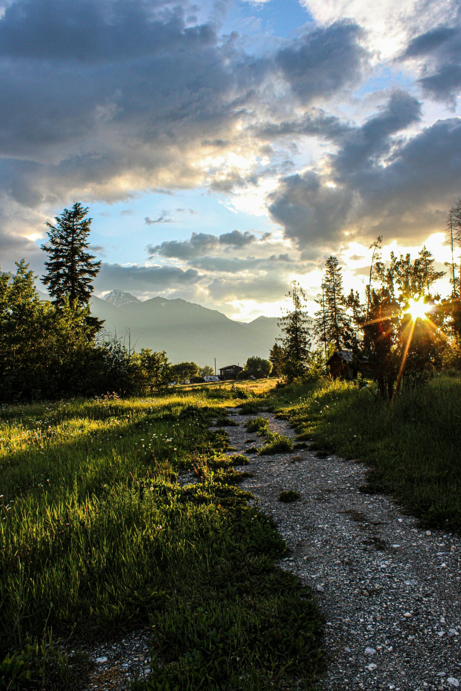A sunlit gravel path leading toward a remote mountain retreat in Portugal at sunset, representing the serene and secluded travel destinations that define Europe’s top wellness sanctuary.