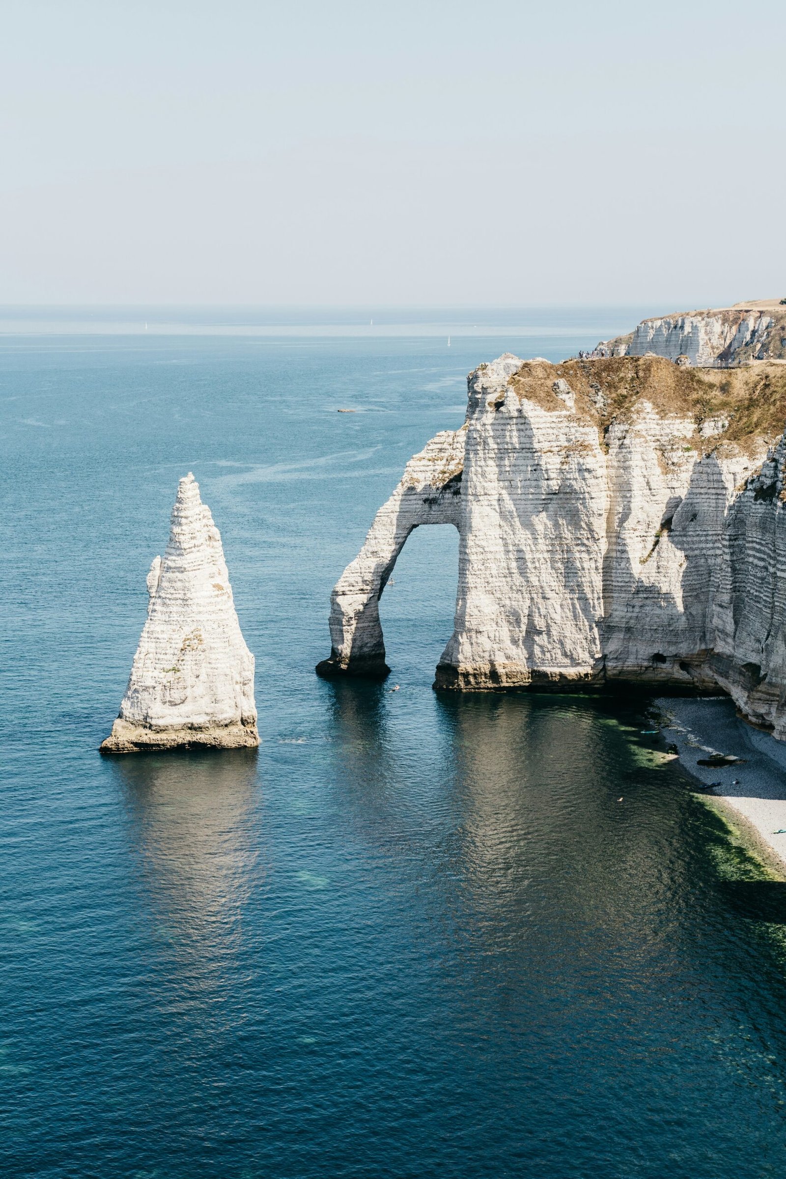 White chalk cliffs and blue sea at Étretat in Normandy, offering a peaceful coastal setting for a France yoga retreat.