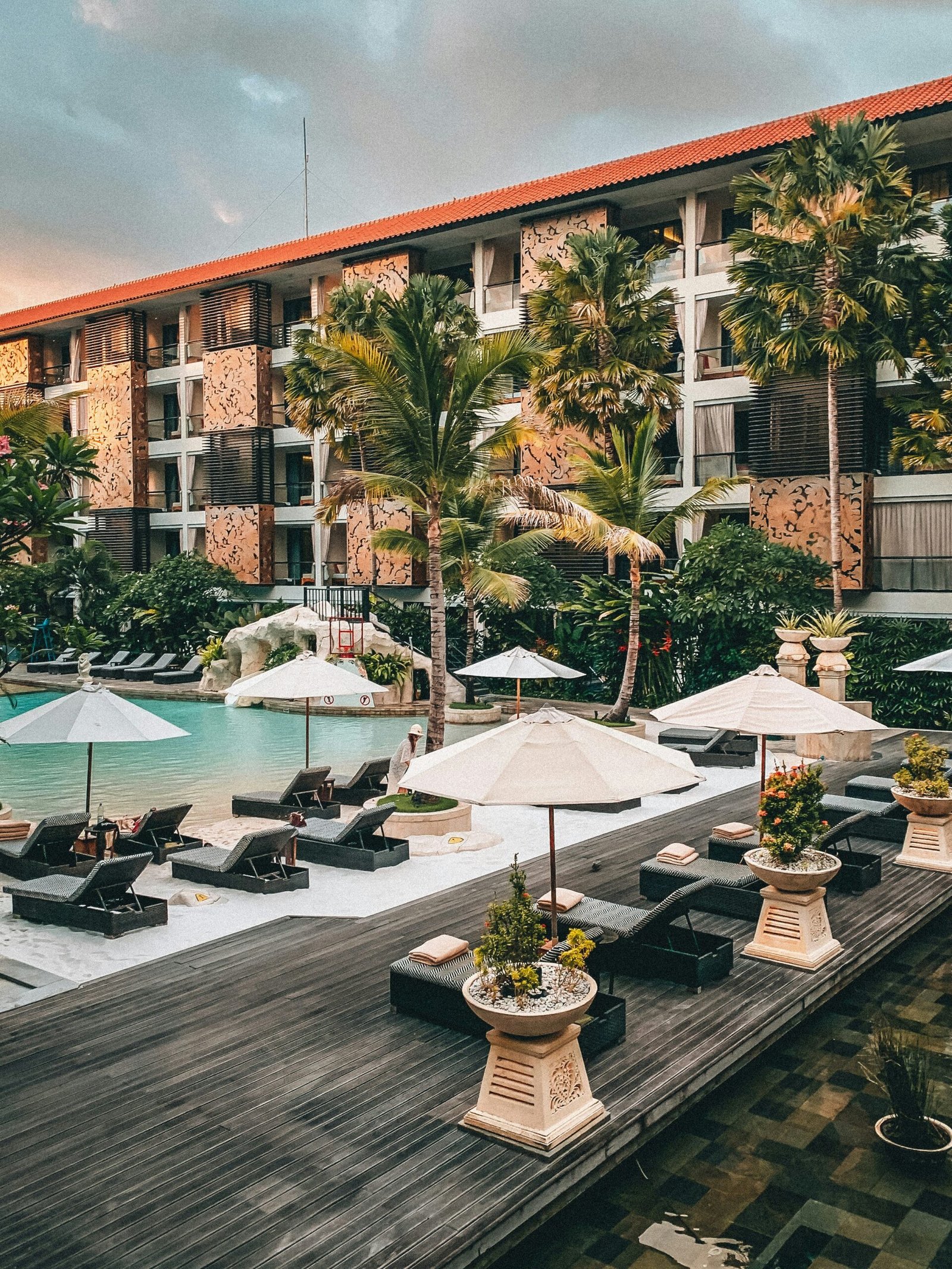Sunlit poolside seating area with white umbrellas at a relaxing retreat hideaway